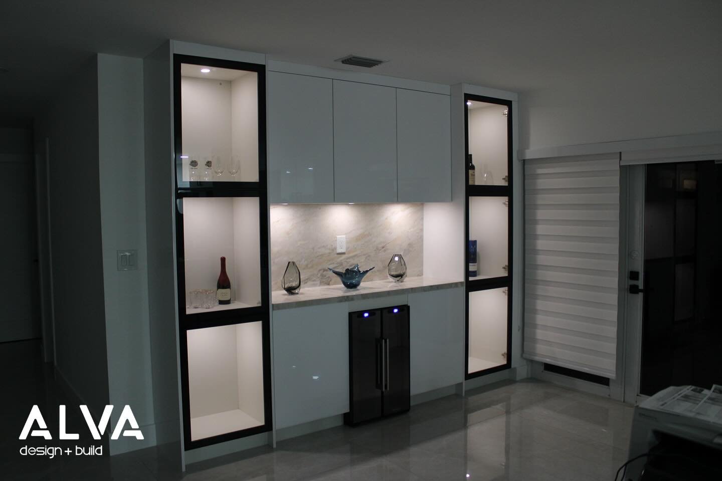 Another project completed in the Colunga residence.

The client had an empty wall space and loved the idea of continuing the kitchen aesthetic by adding a custom bar.

The bar features timeless acrylic white doors and panels, complemented by accent b