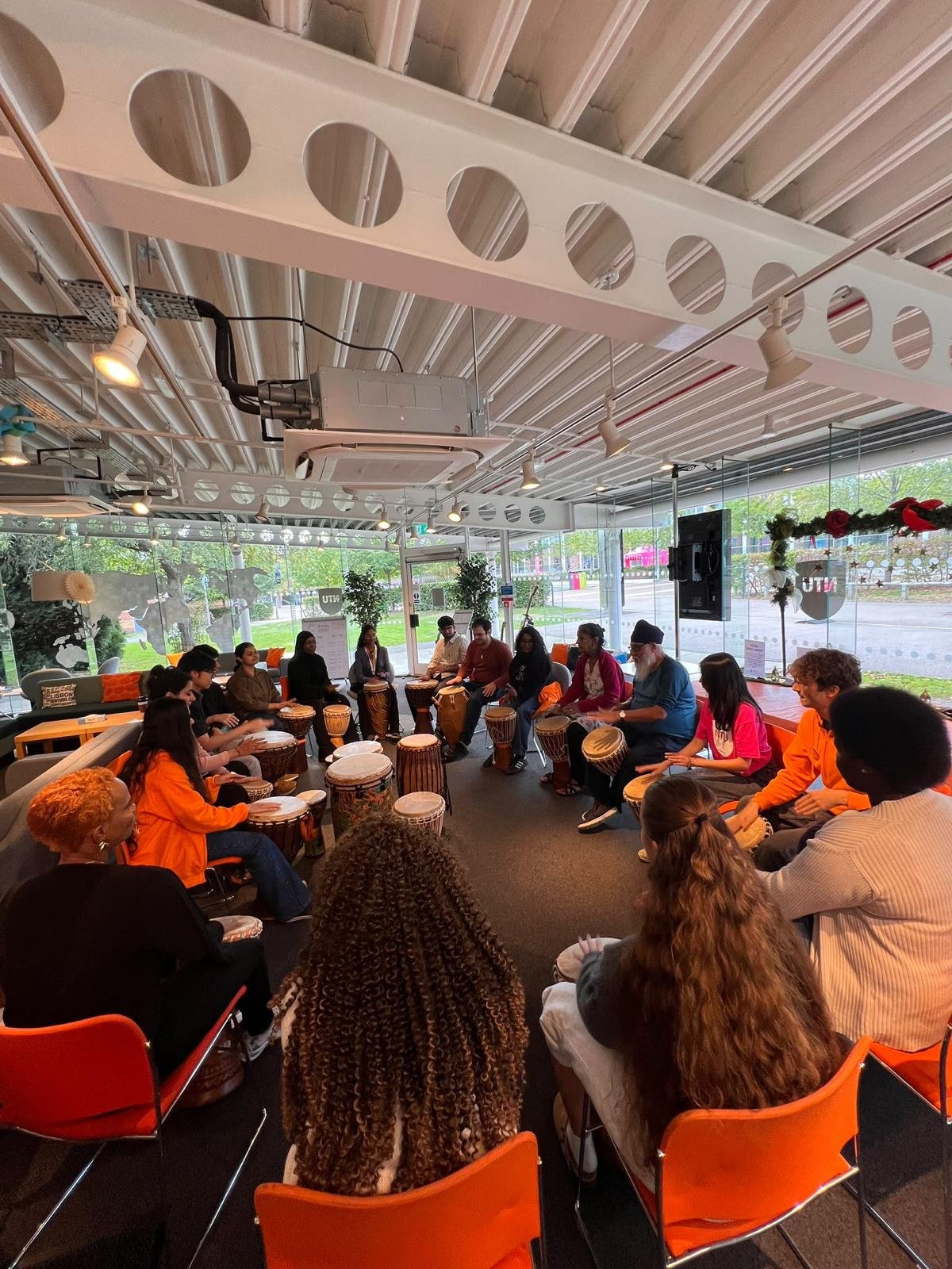 Therapists and professionals taking part in an experiential community drumming workshop exploring rhythm, connection, reflection and teamwork.