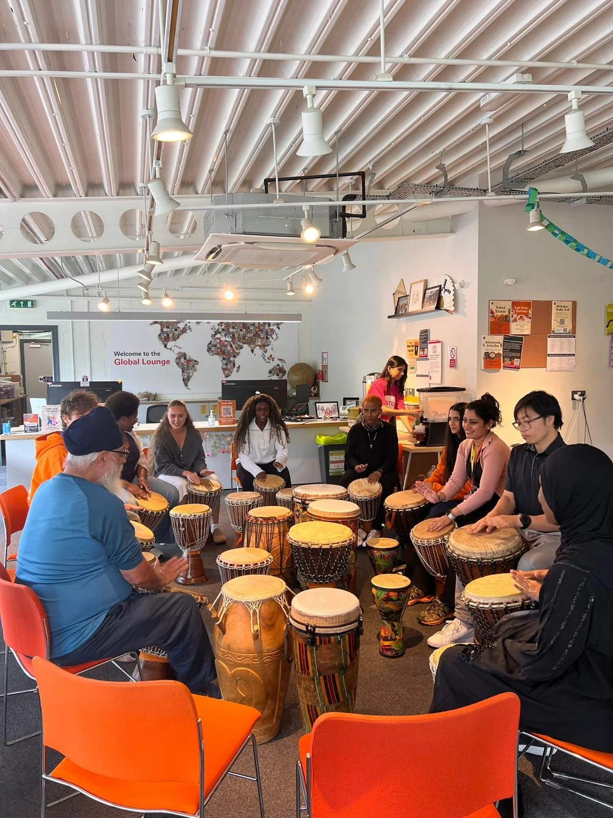 Participants playing hand drums together during an experiential workshop for play therapists, encouraging connection, creativity and reflective practice.