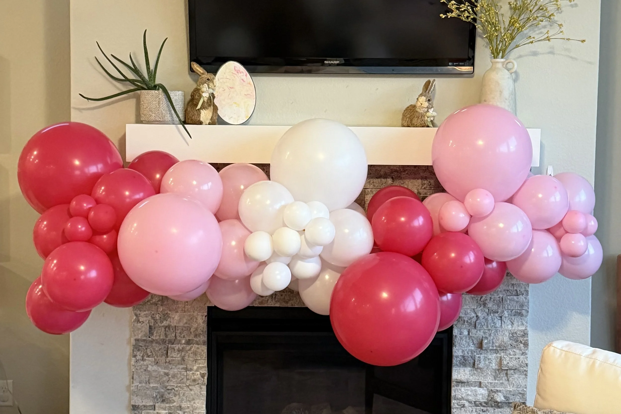 Mantle draped in valentine's day balloon garland with red, white and pink balloons, created by Dripping springs based ColorPop Balloon Studio.
