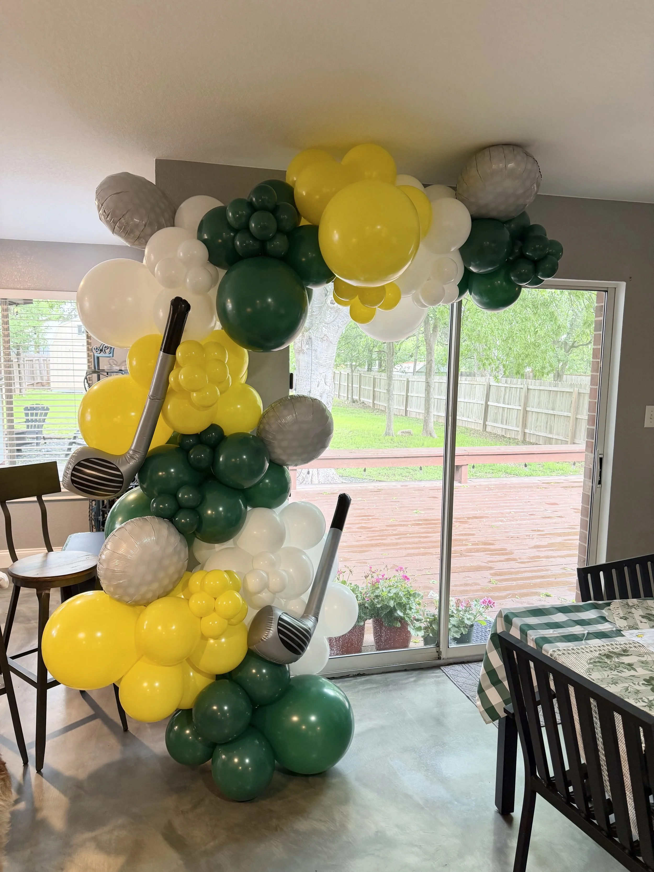 Masters golf themed balloon arch in green, yellow and white with additional golf club balloons, created by Dripping springs based ColorPop Balloon Studio.