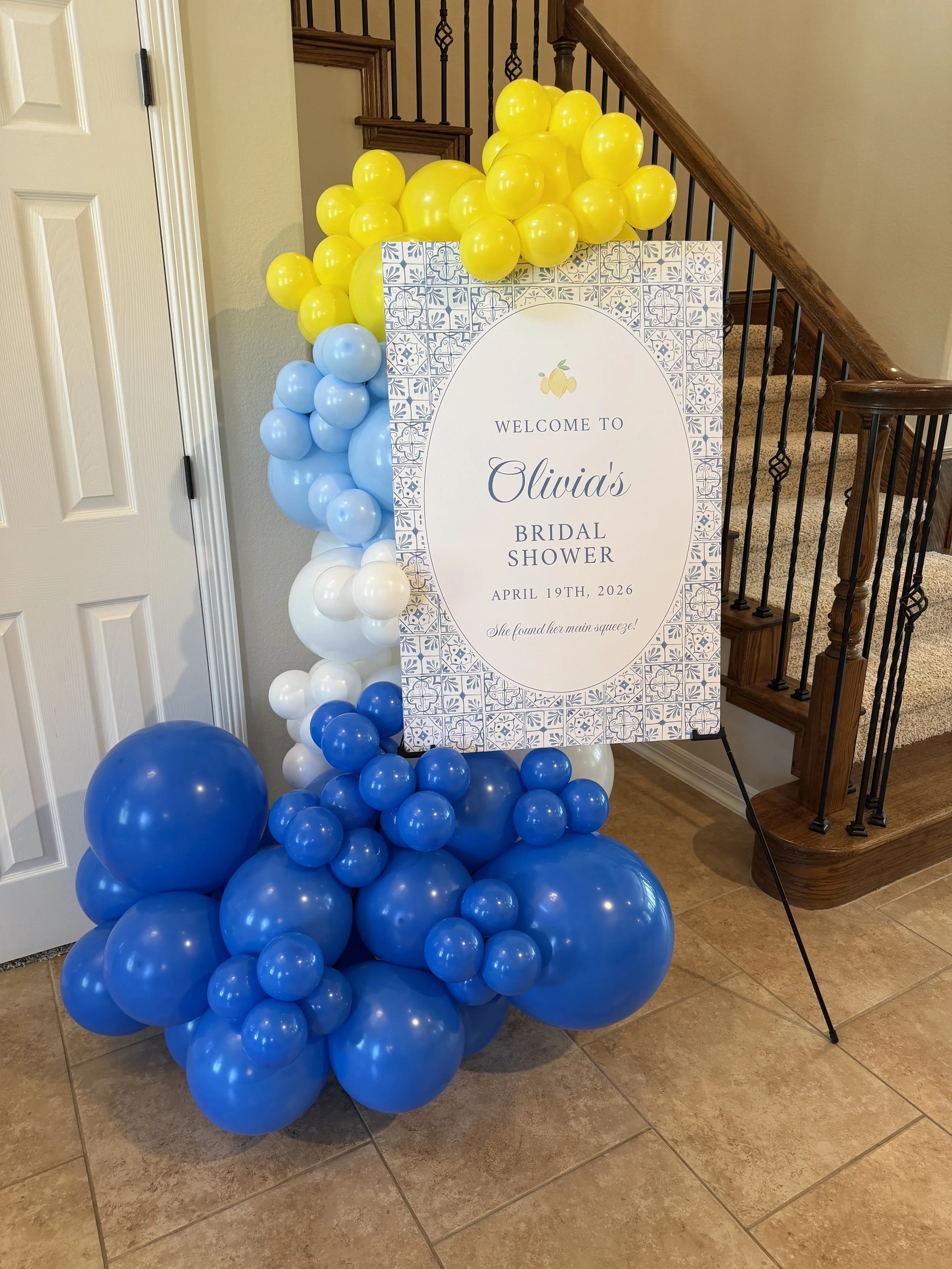 Wedding shower welcome sign with blue, yellow and white balloon garland wrapped around it, created by Dripping springs based ColorPop Balloon Studio.