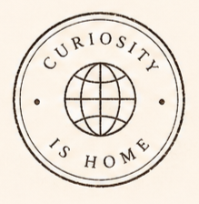 A circular logo with the words 'Curiosity Is Home' and an illustration of a globe in the center.