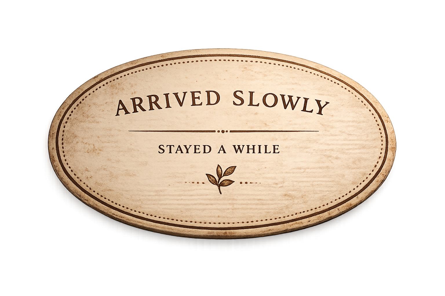 Wooden sign that says "Arrived slowly, stayed a while" with a small leaf drawing at the bottom.