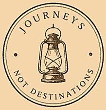 A circular logo with a vintage lantern in the center. Around the lantern, the words 'JOURNEYS NOT DESTINATIONS' are written.