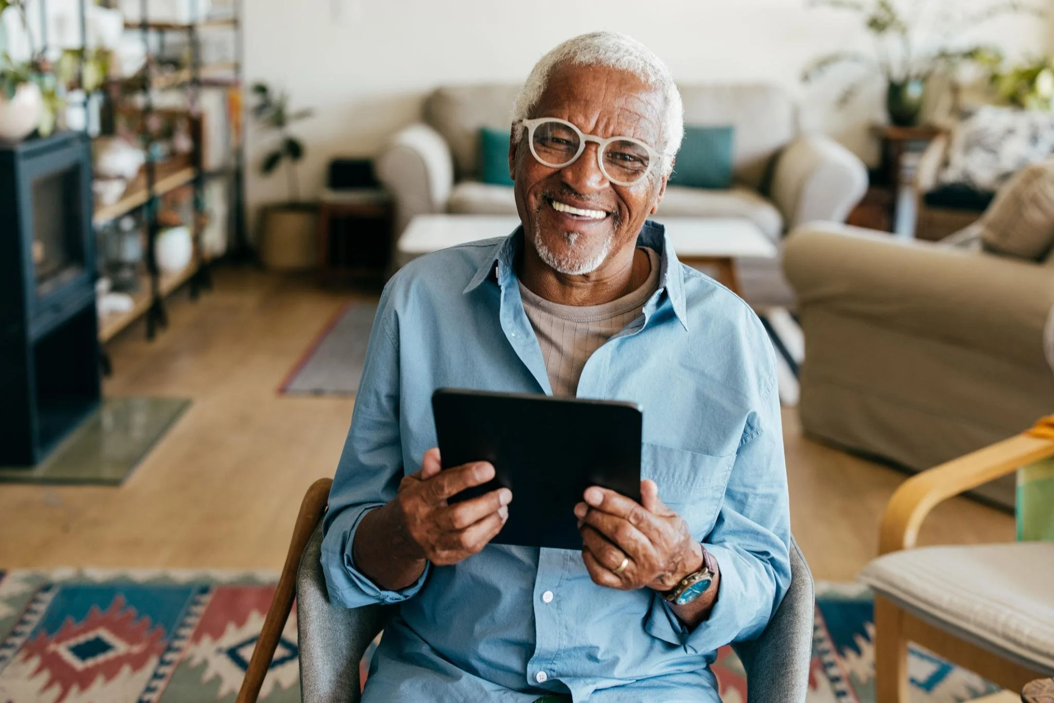 An older adult using a tablet independently in a relaxed home environment