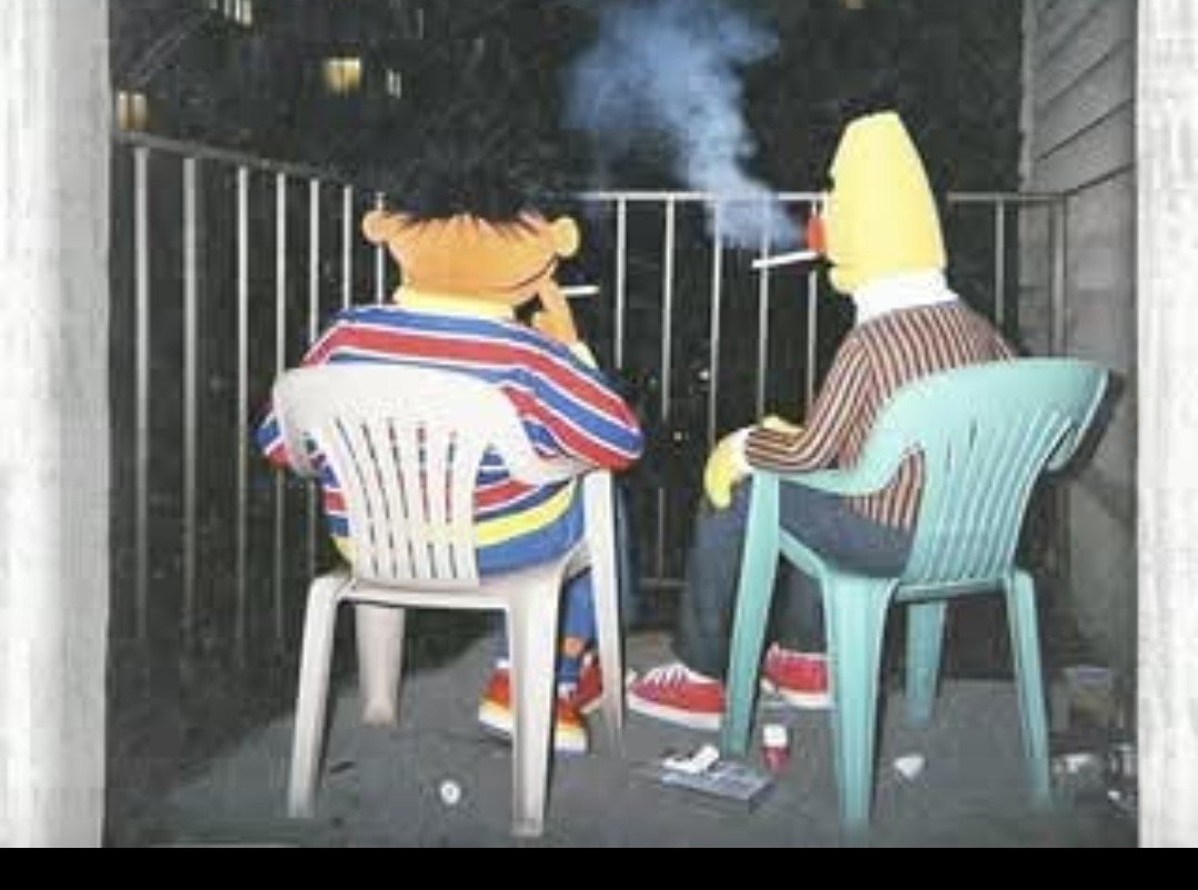 Two cartoonish characters sitting on chairs on a balcony, watching smoke from a cigarette or cigarette-shaped object.