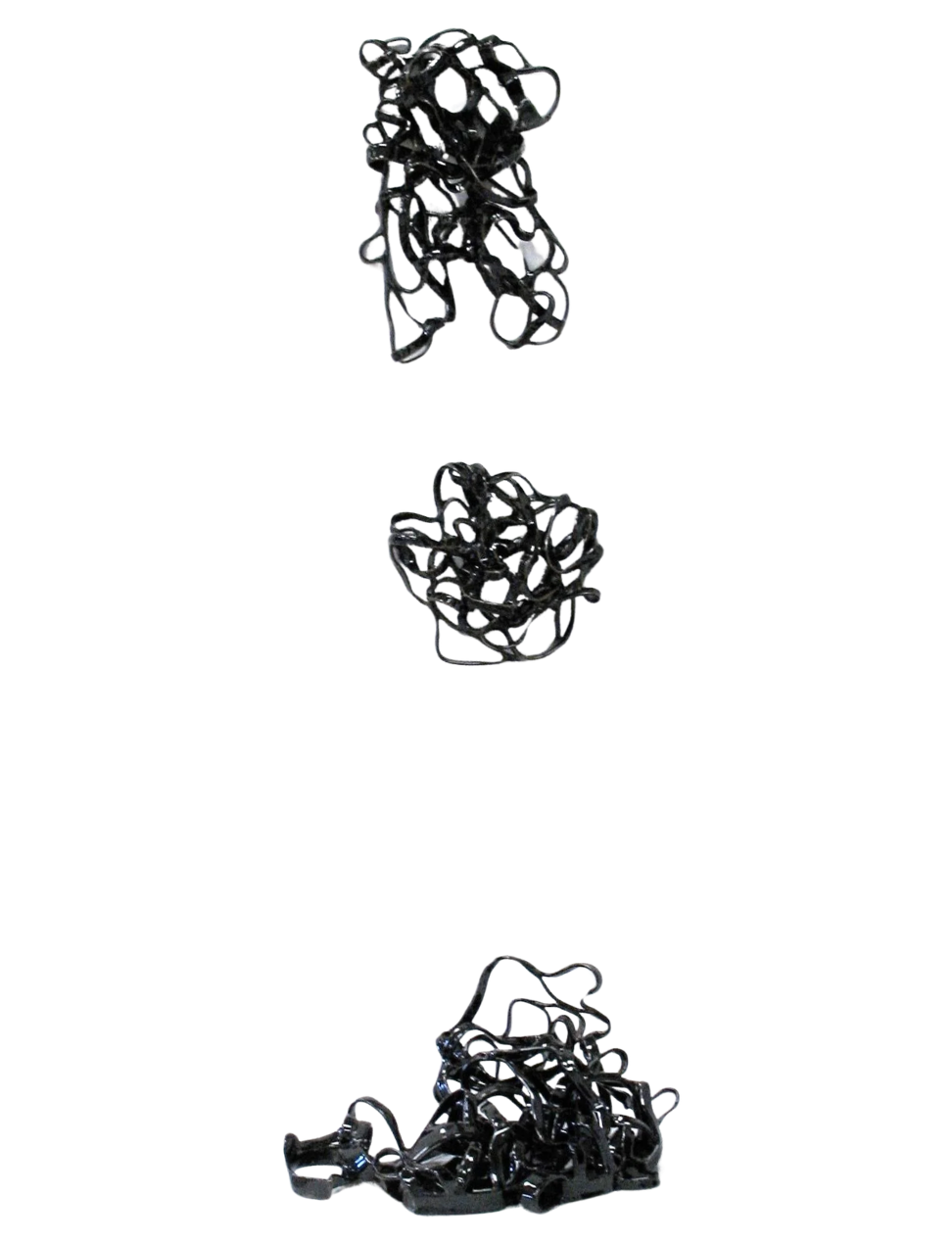 Three tangled black hair elastics placed vertically across a white background.