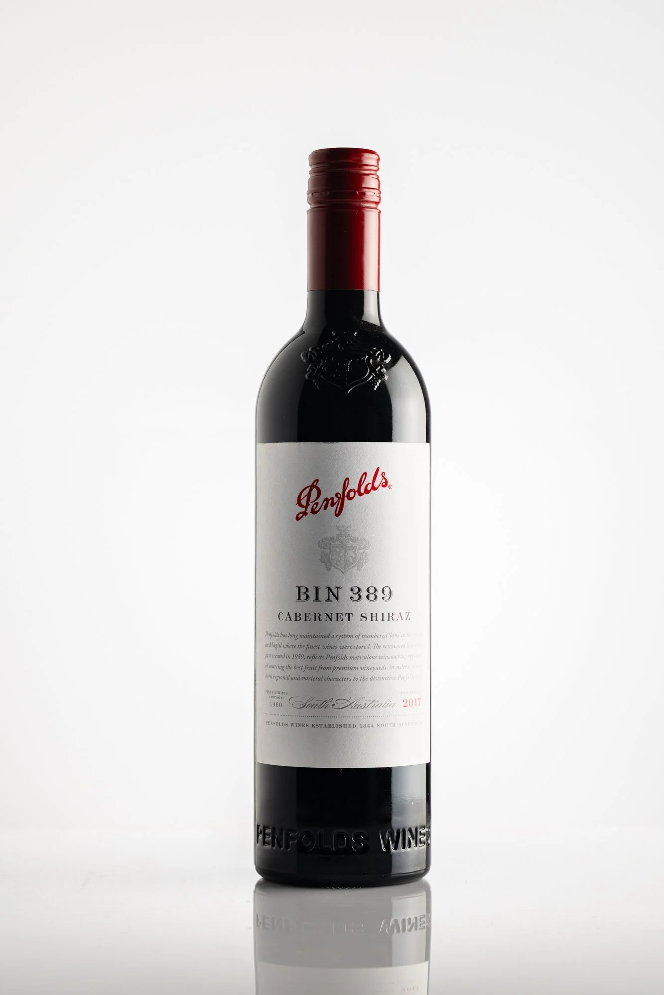 A bottle of Penfolds Bin 389 Cabernet Shiraz wine against a white background with a reflection on the surface. product photography