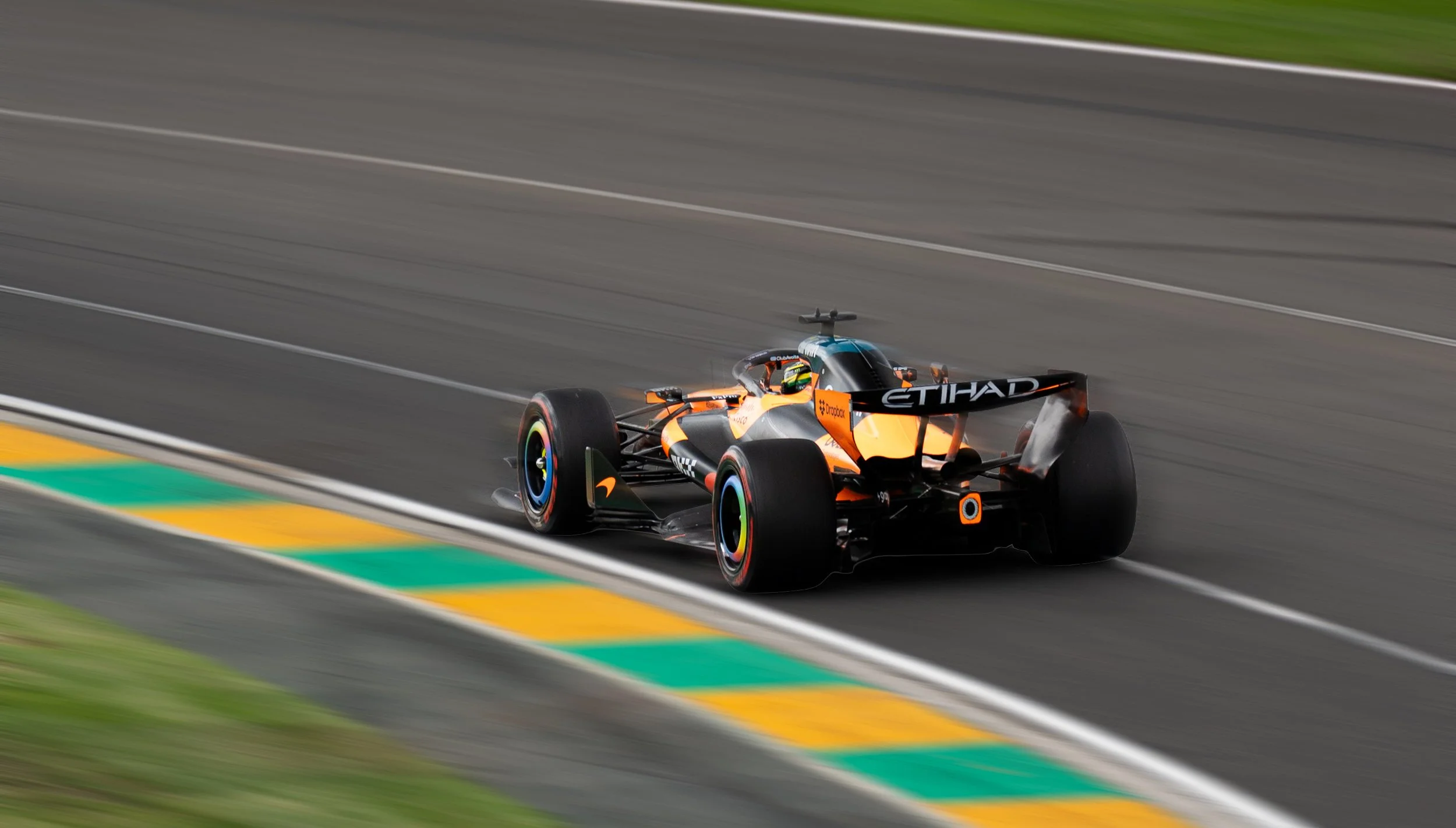 A Formula 1 race car in orange and black speeds along a racing track. Oscar Piastri Australian Grand Prix 2026 racing for McLaren Formula 1 Team motorsport photography