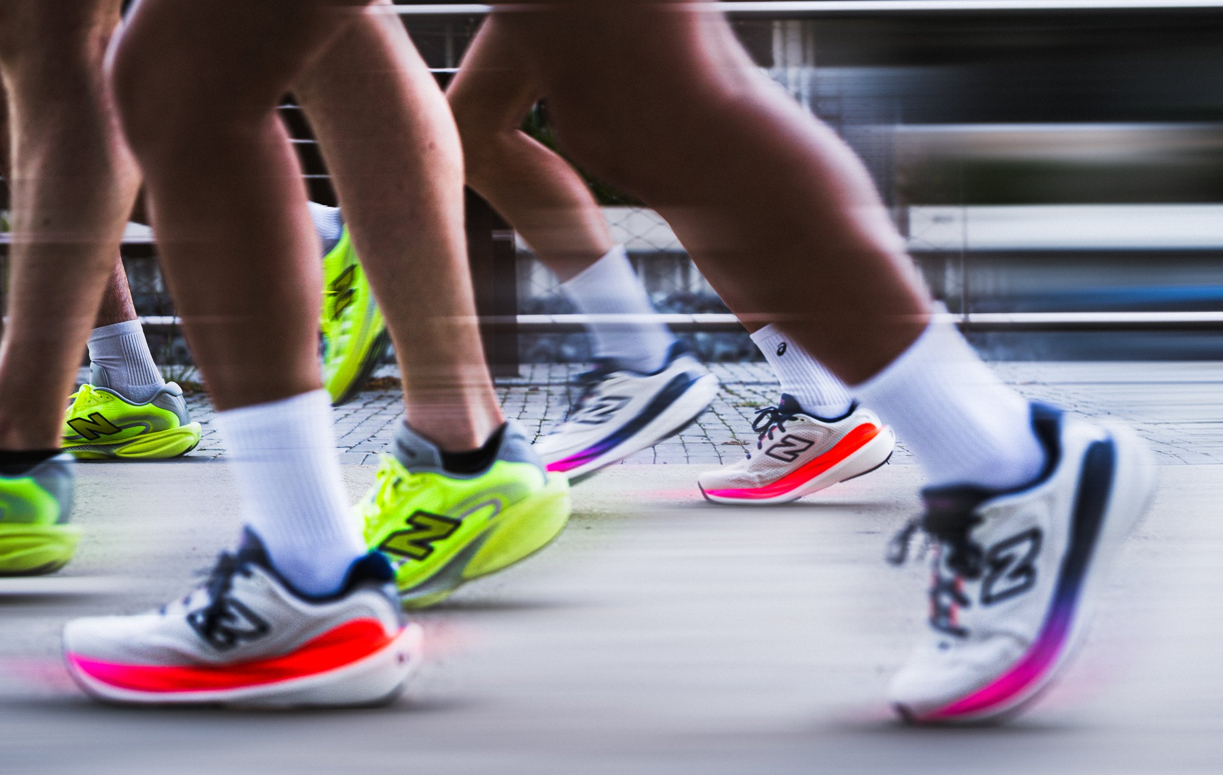 Close-up of runners' legs and colorful running shoes as they start a race from a low angle shot. New Balance running field test run club Canberra editorial sports photography branding 