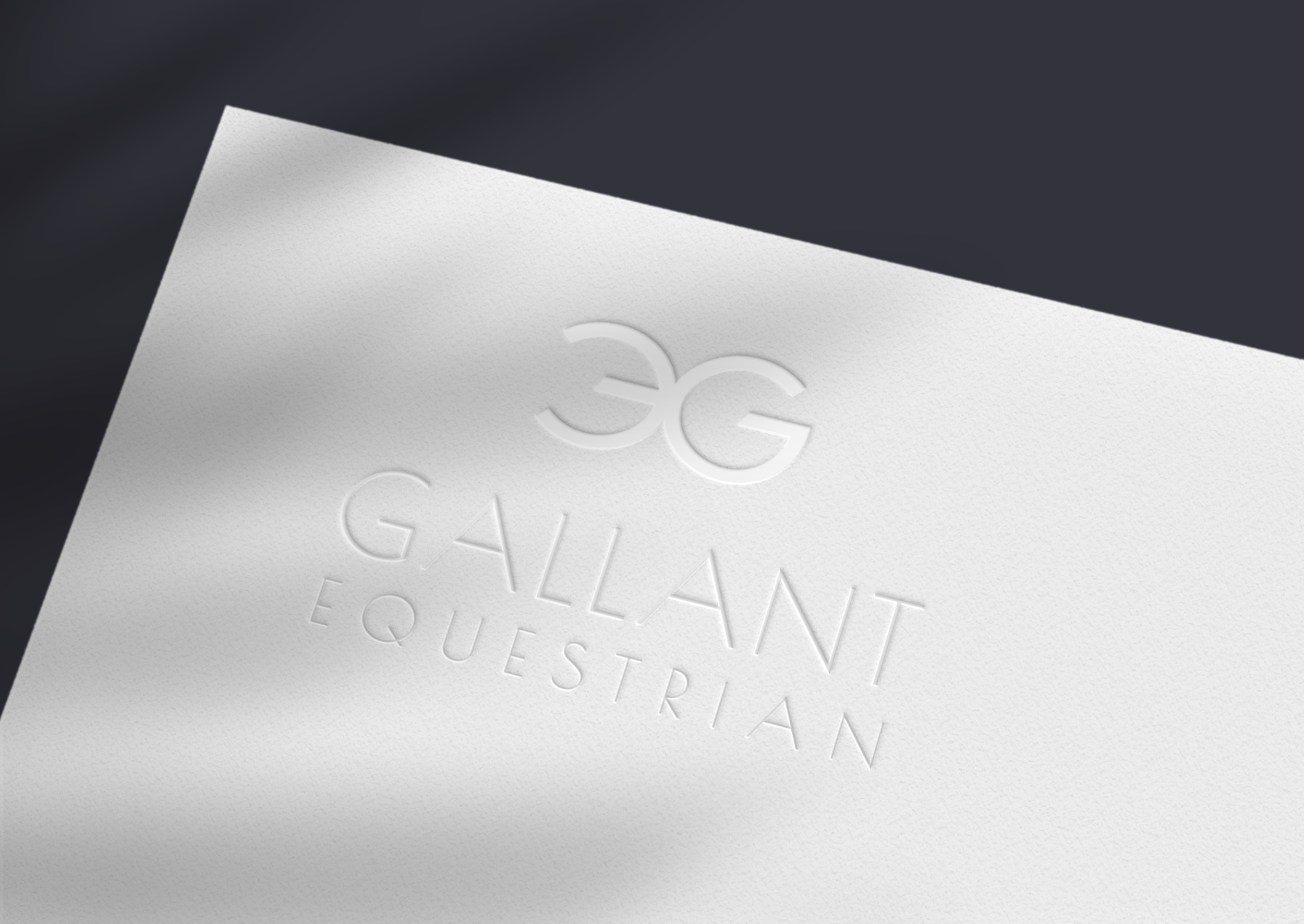 Equestrian brand design for men's apparel range. Close-up of embossed text on a white business card, with the word 'GALLERY' partially visible.