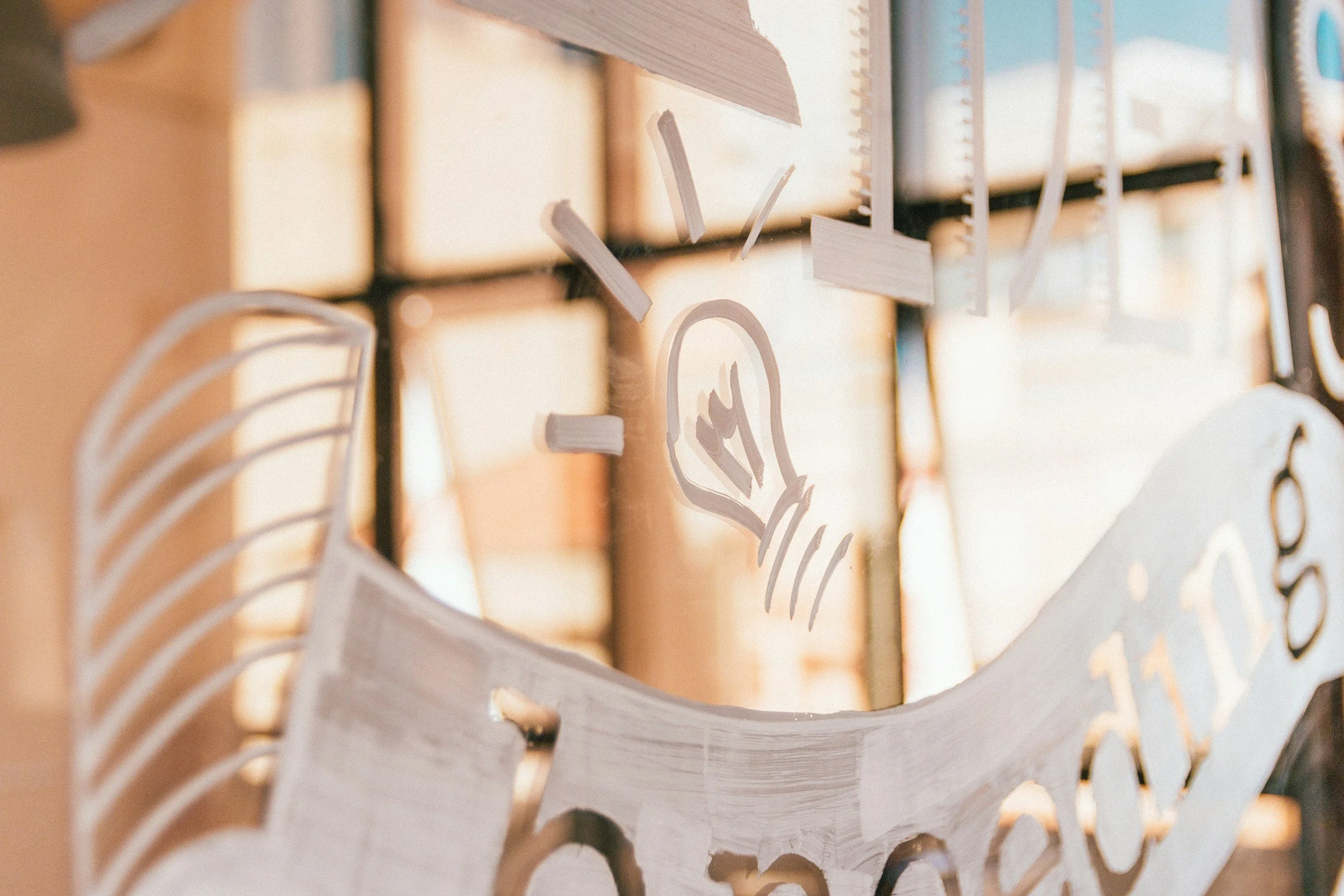 A close-up of a decorative wooden board with carved patterns and white painted letters.
