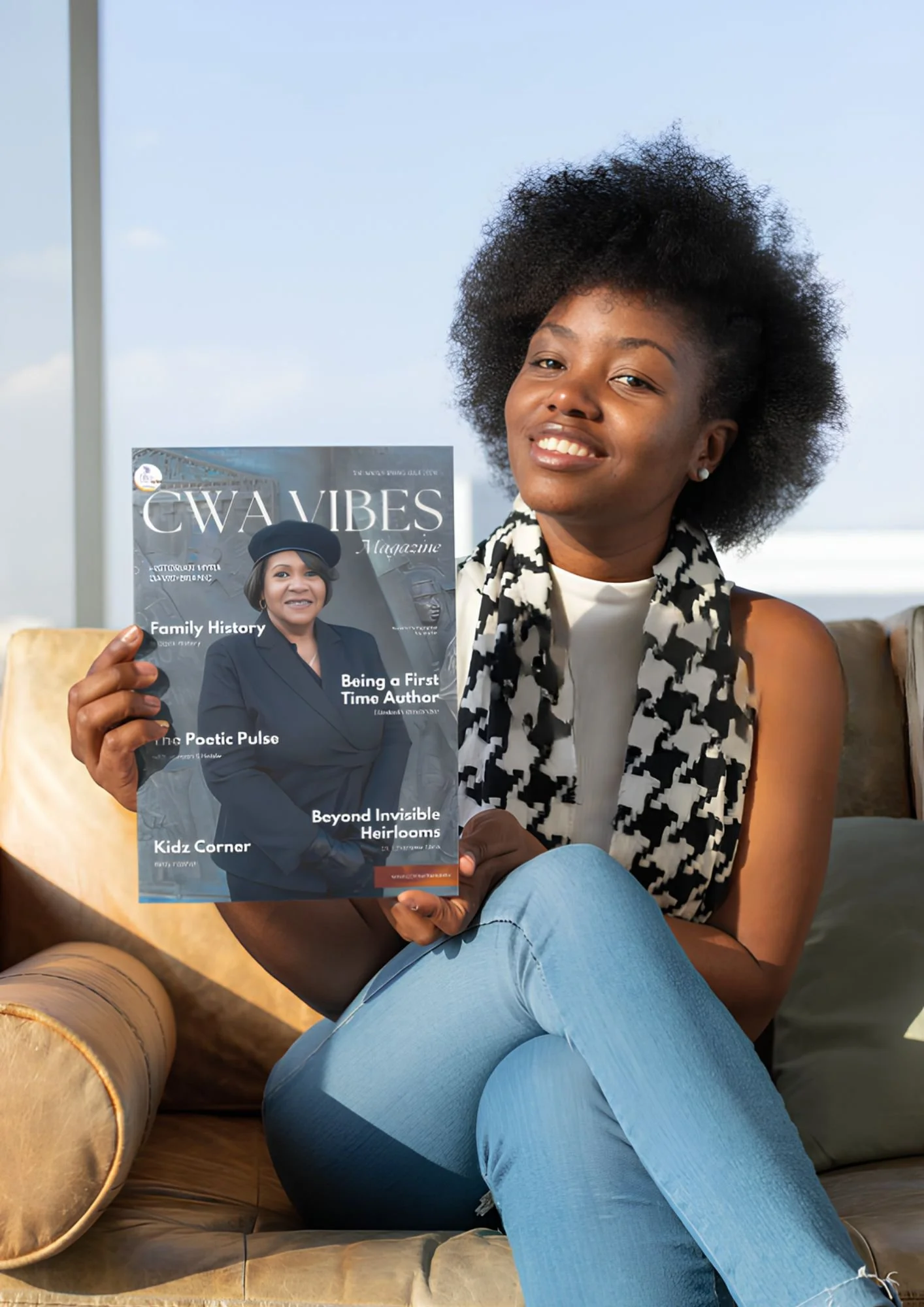 A woman sitting on a tan leather sofa outdoors, holding a magazine titled 'CWA VIBES Magazine' featuring an African American woman on the cover. The woman is smiling, with short curly hair, wearing a black and white patterned scarf and sleeveless top. The background shows a pale blue sky with wispy clouds.