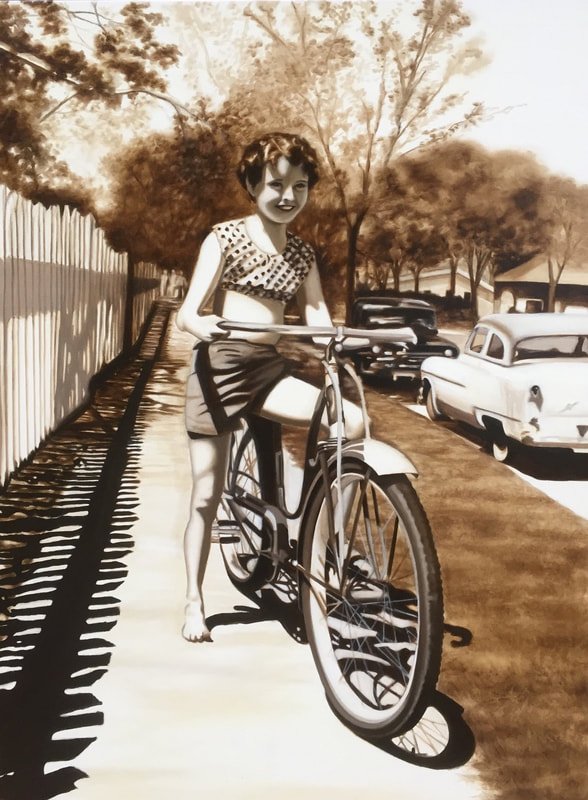 A young girl with short curly hair smiling, riding a bicycle along a sidewalk. Behind her, there are vintage cars parked and trees lining the street. The scene is in sepia tones, giving a nostalgic feel.