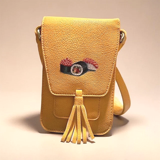 Yellow handbag with embroidered camera design on the front, tassel detail, and shoulder strap.