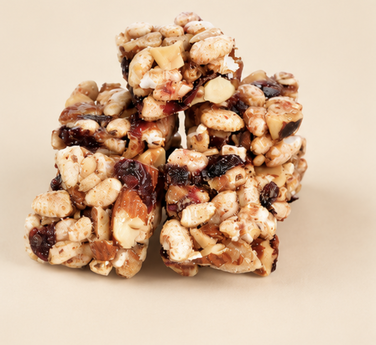 Granola bar with oats, nuts, and dried berries on a white background.