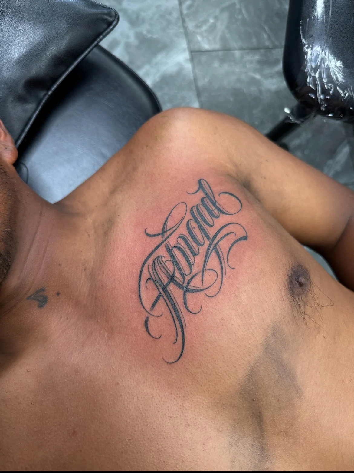 A person's upper chest with a tattoo that reads 'Hopeful' in cursive script.