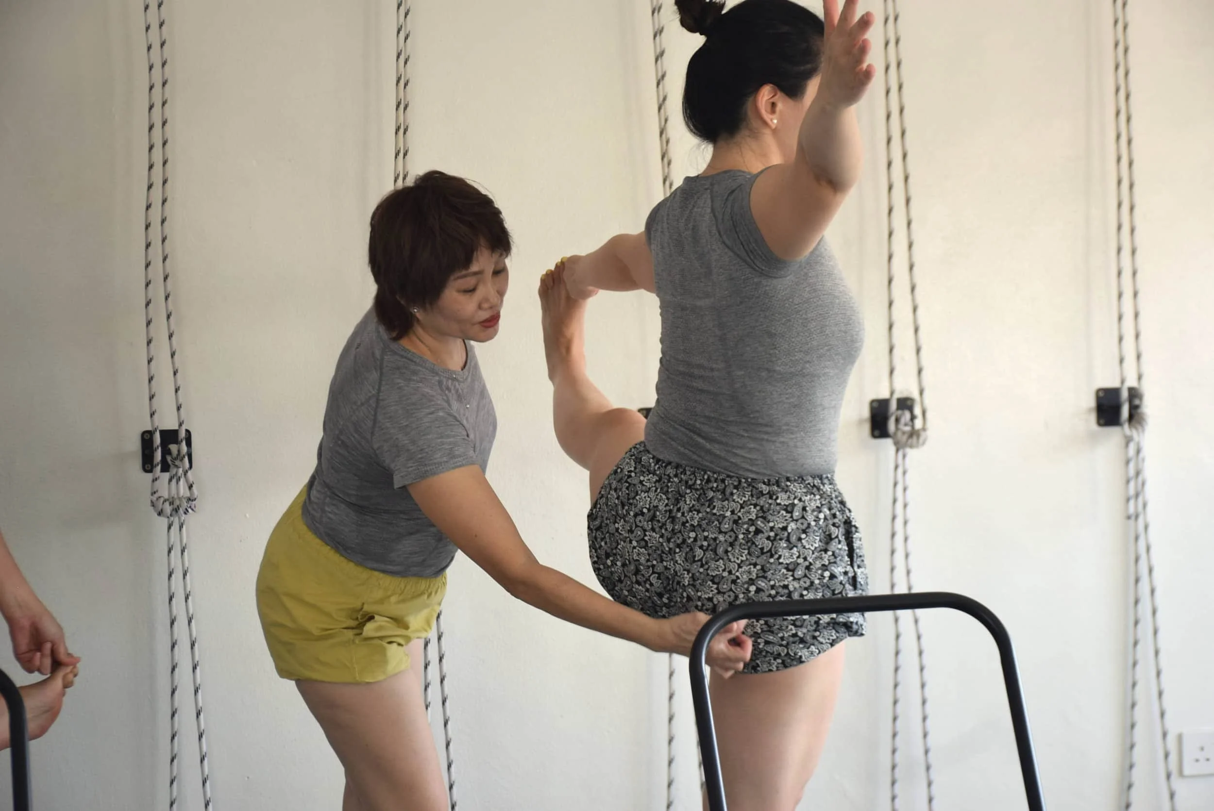Yga teacher correcting student's poses in a Kepong yoga studio