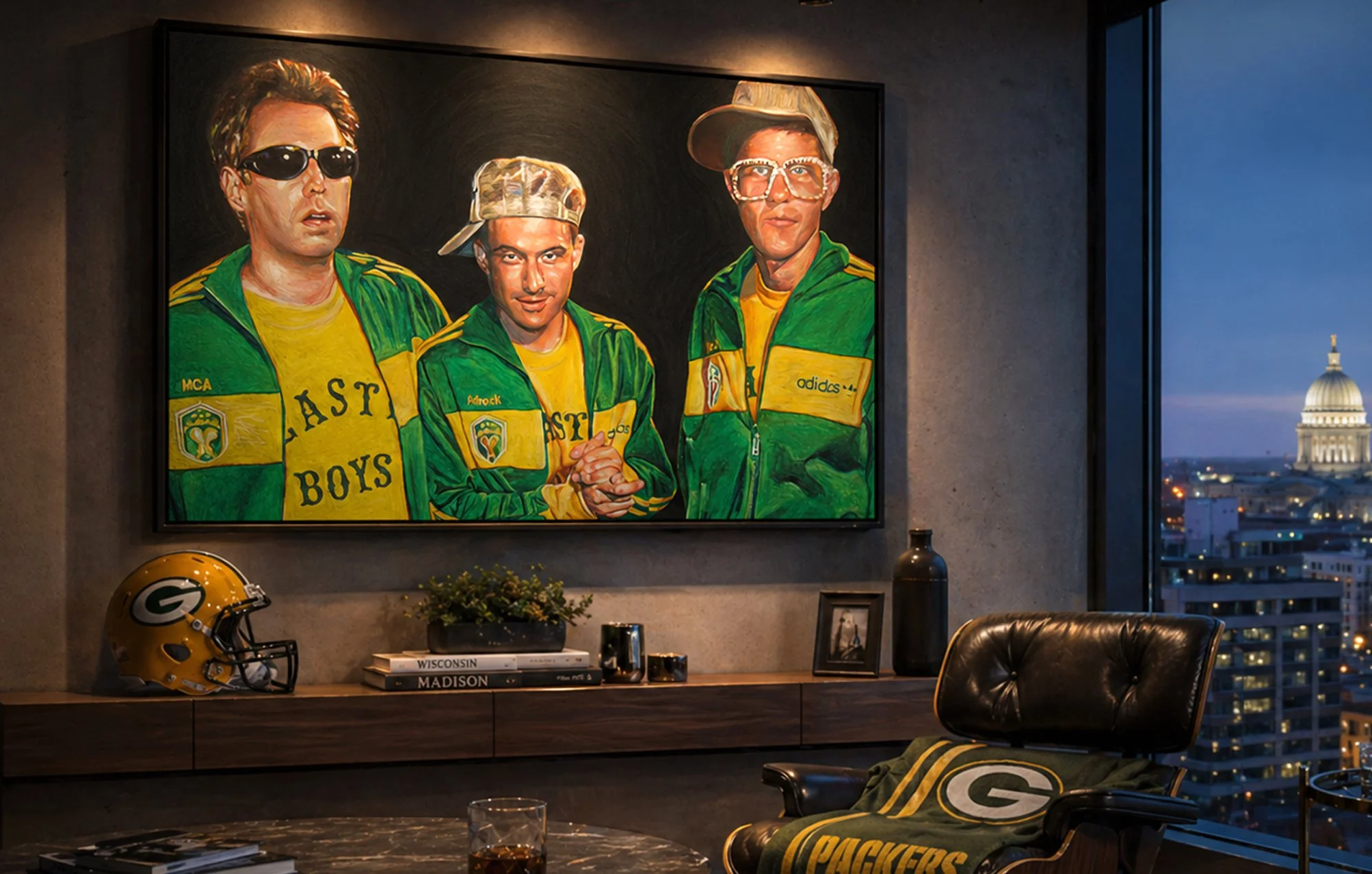 A colorful painting of three men wearing green and yellow sports jackets, with one in sunglasses, another with a cap, and the third with large glasses and a cap, displayed on a wall in a modern room with city skyline view at dusk.