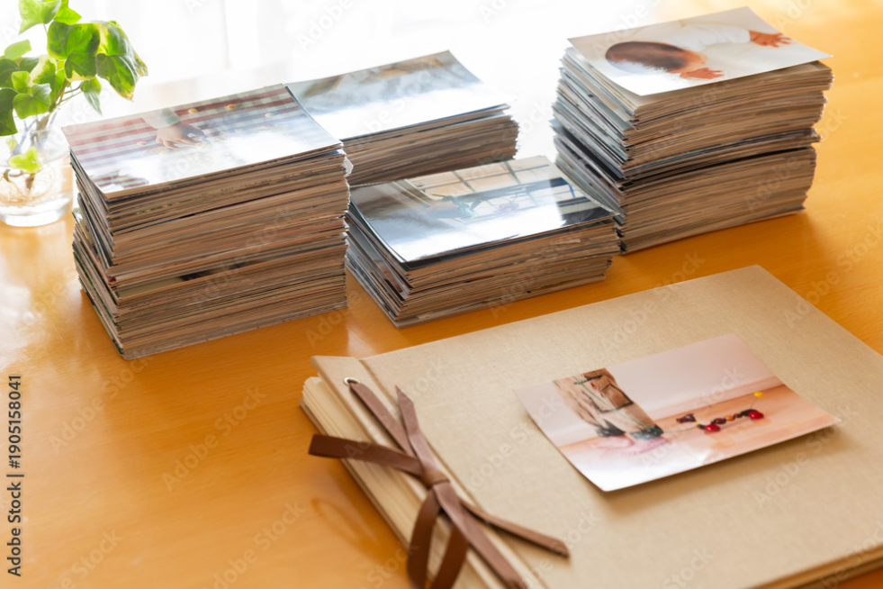 Stacks of photos sitting on a table behind a scrapbook