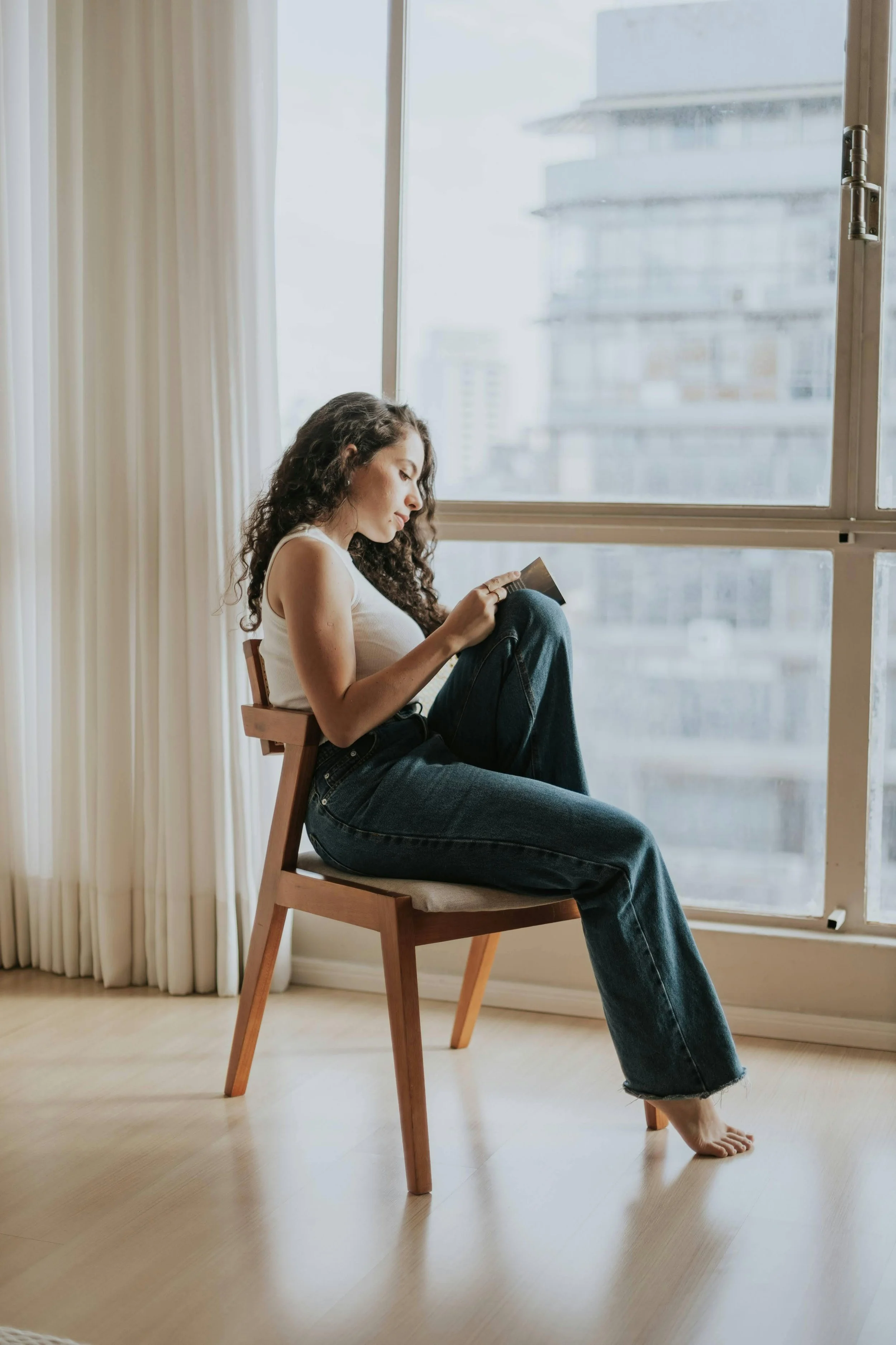 Woman sitting by a window taking time to think or plan through her website layout
