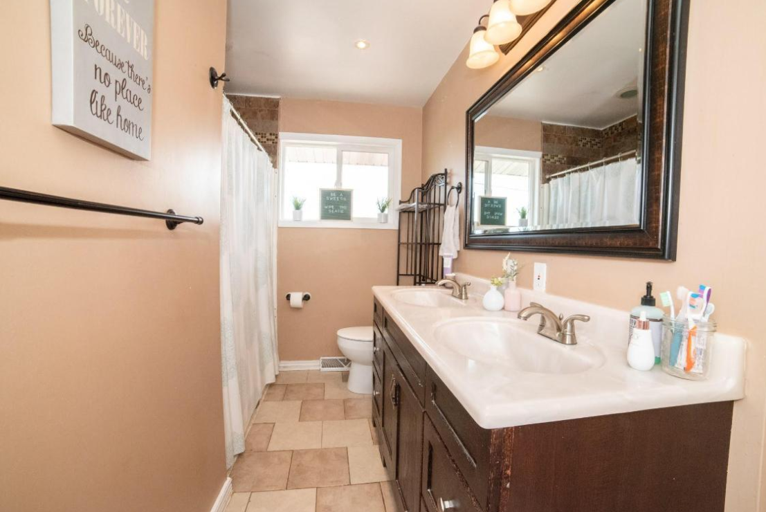 Clean guest bathroom with polished sink, mirror, and fixtures by Curated Cleaning Co.