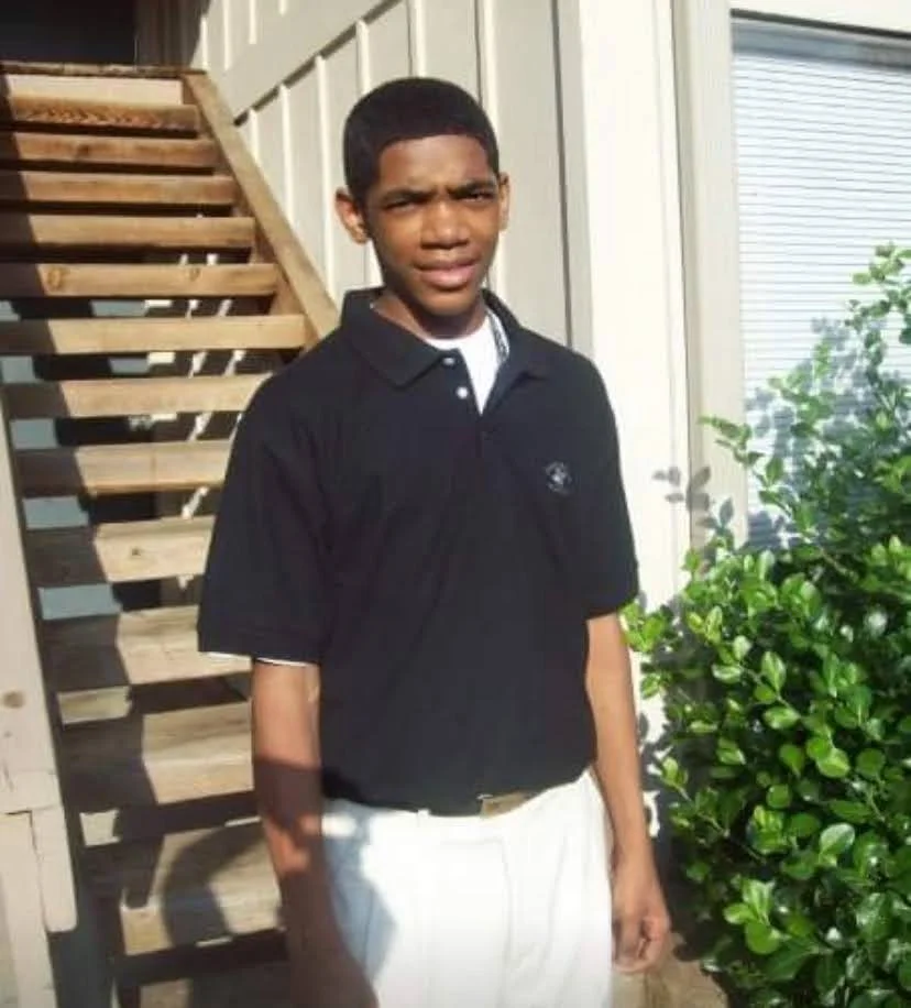 Teenager Corey Webb Standing in the sun wearing a black polo