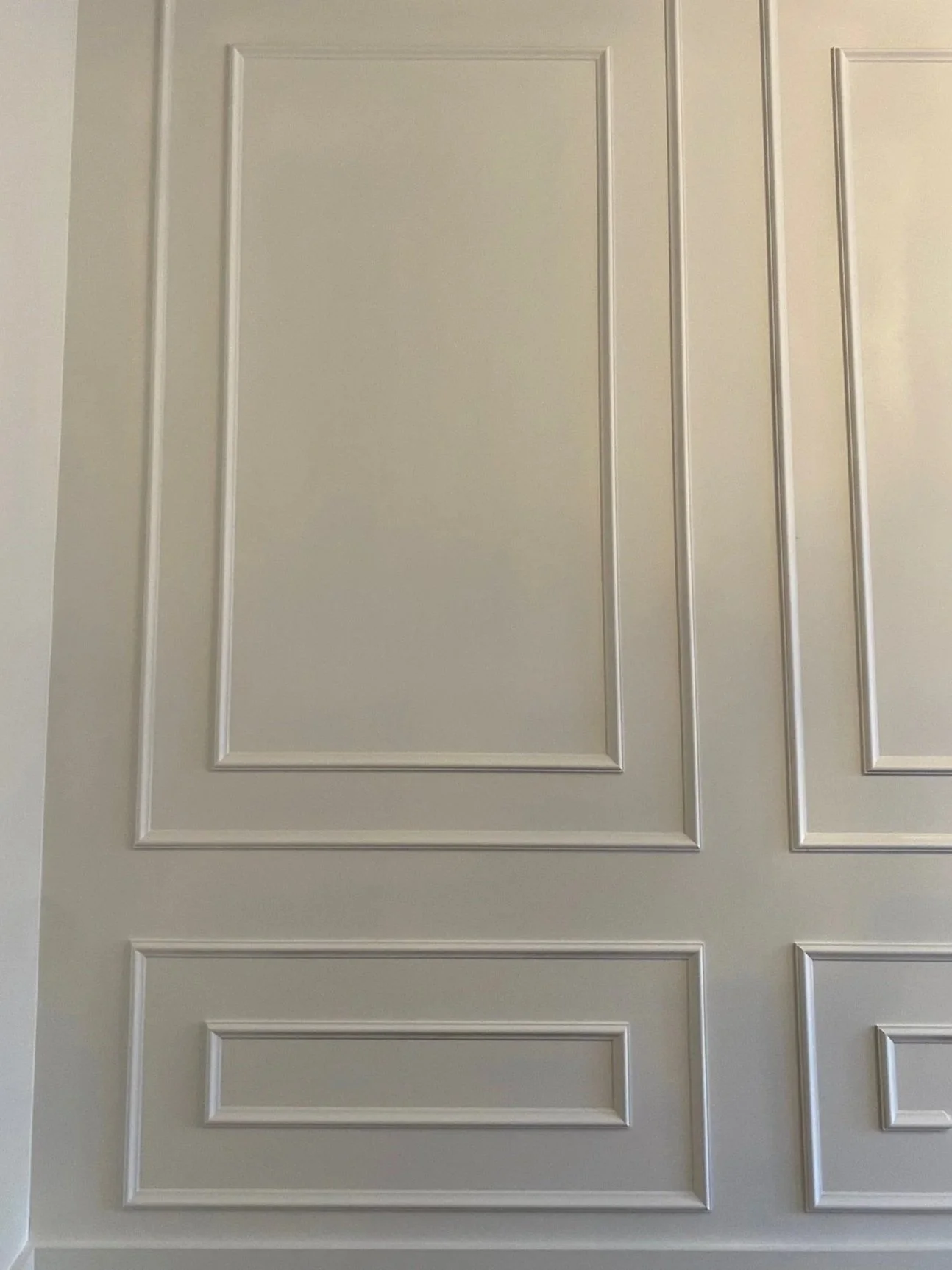 White bedroom wainscotting with decorative molding.