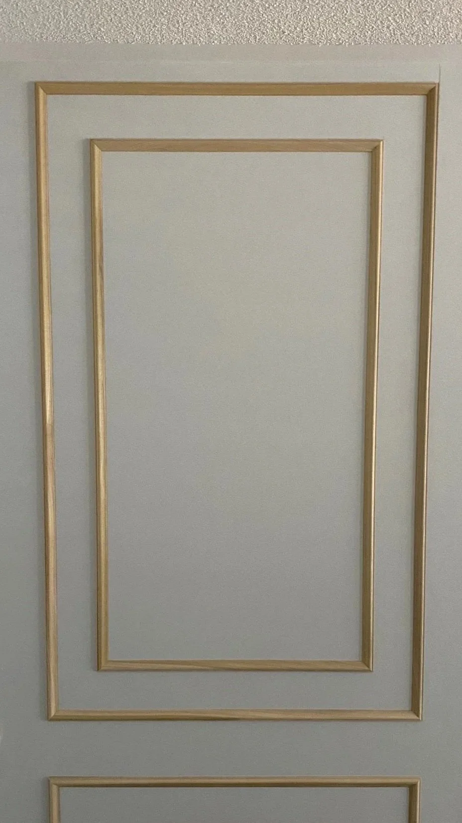 Close-up view of a decorating panel with rectangular wooden trim accents.