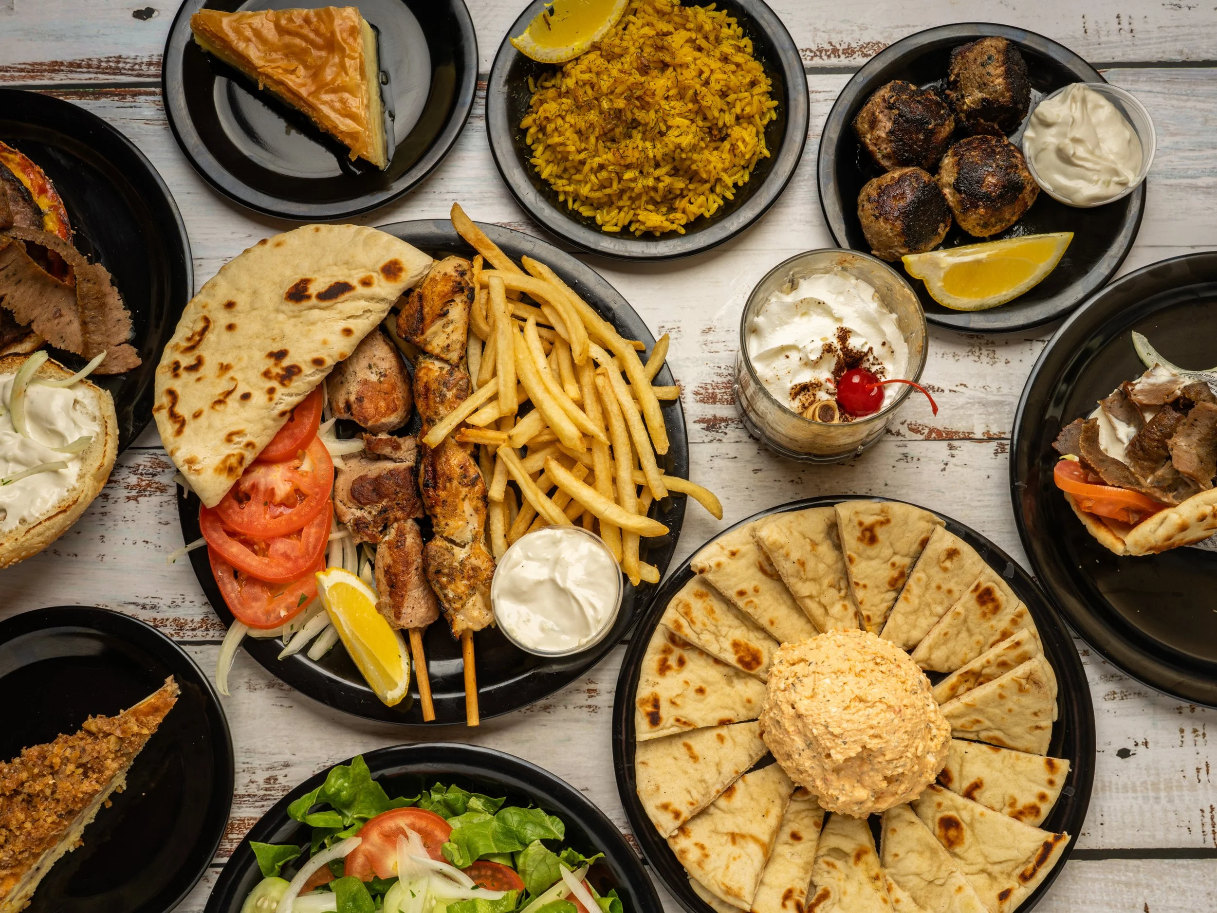 Hero image of To Steki website with assortment of greek dishes