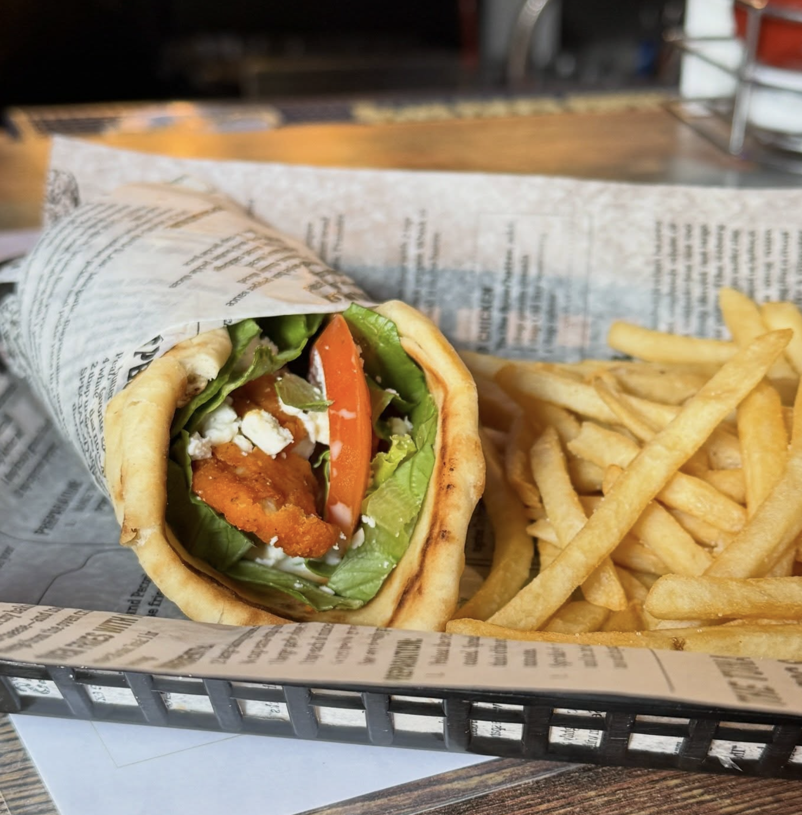 Greek fried chicken pita wrap with lettuce, tomato, feta, and fries