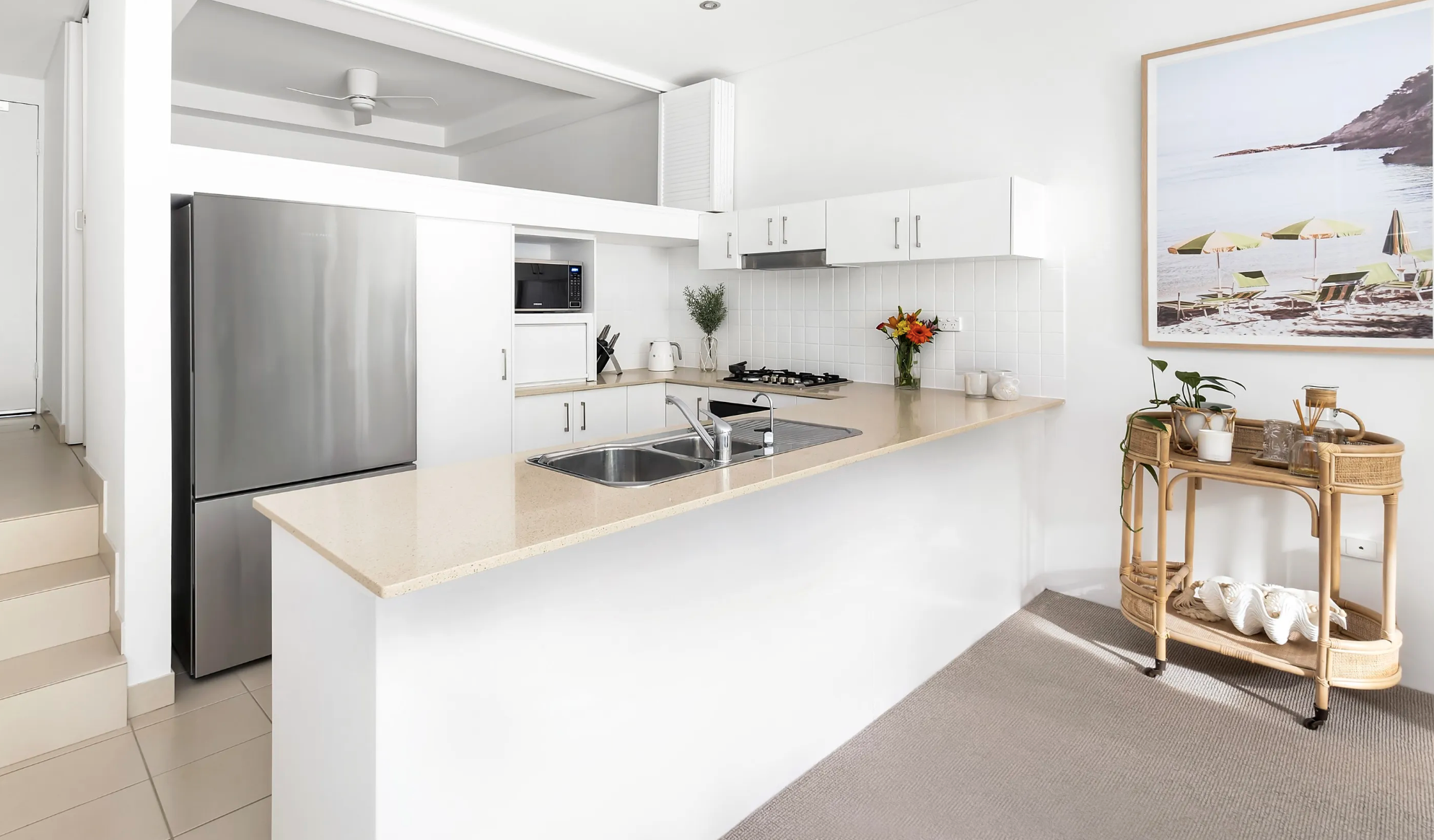 After: Existing cabinetry & tiles were resprayed in white to create a brighter, more contemporary kitchen, achieving a high-impact update without a full renovation.