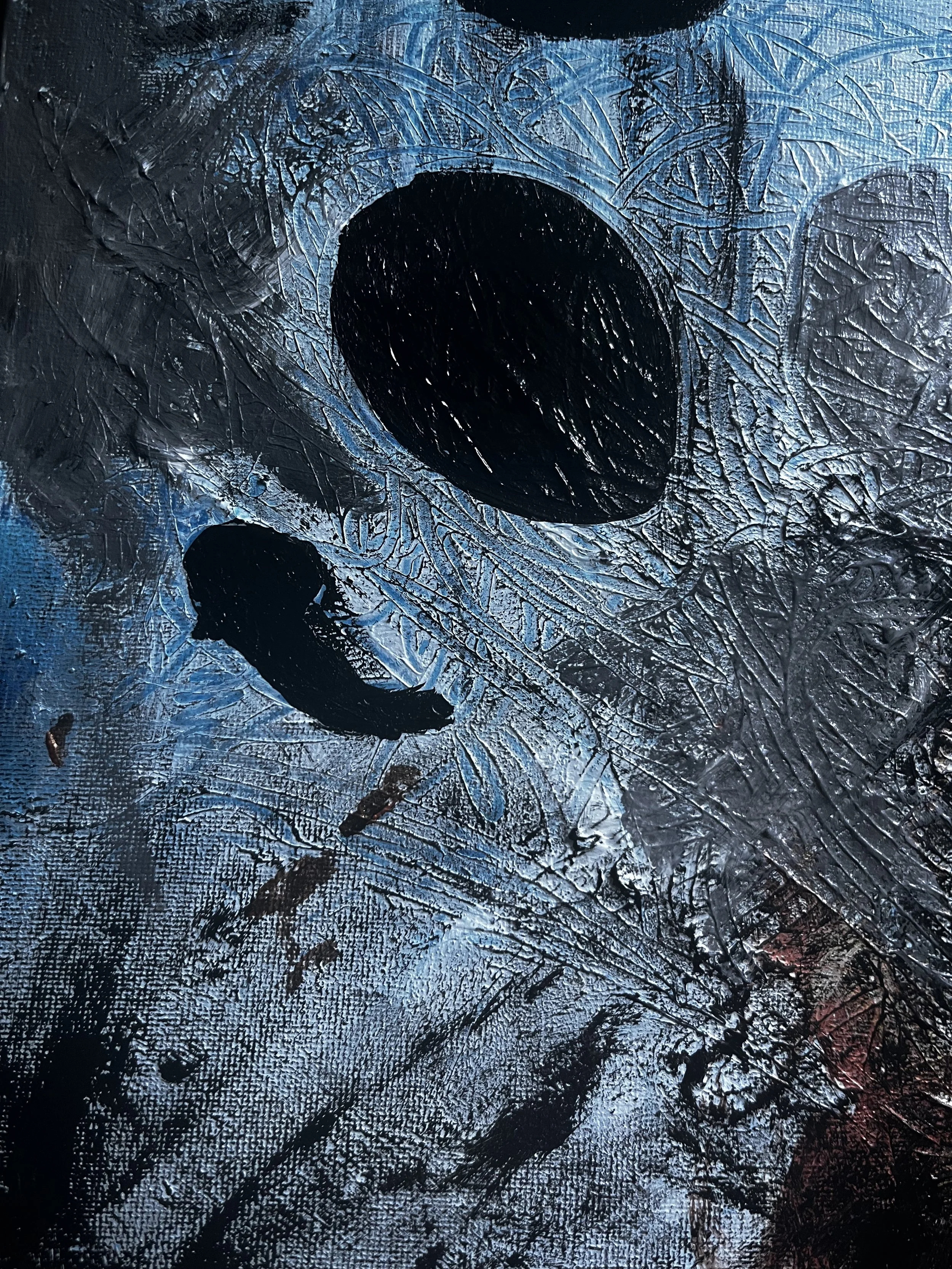 Close-up of an abstract painting with black, blue, and hints of red textures and brush strokes.