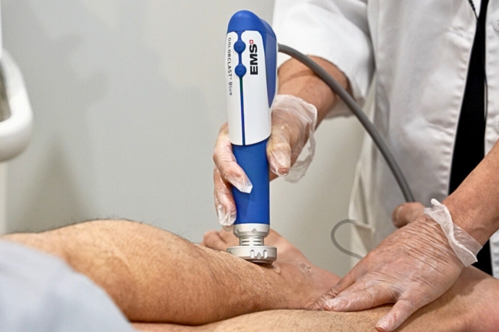 Healthcare professional using ultrasound device on a patient's arm.