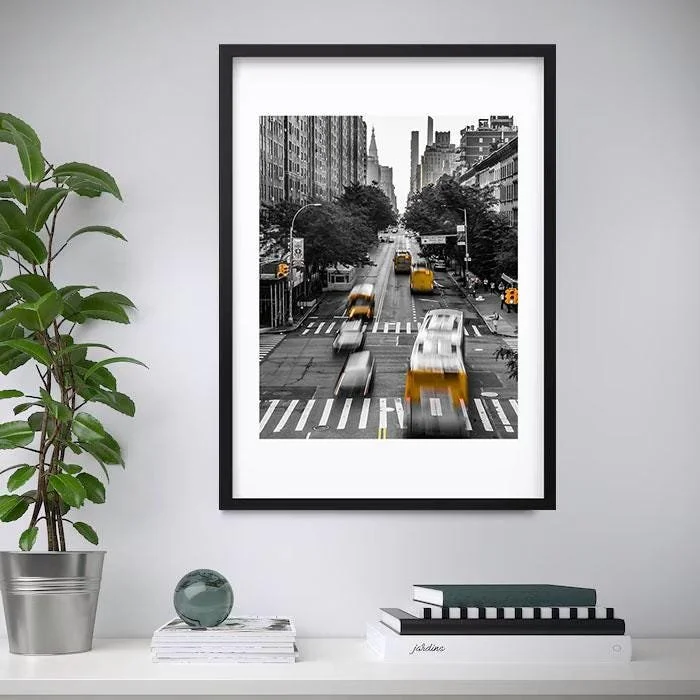 Black and white city street scene with yellow taxis, blurred for motion, seen through a window.