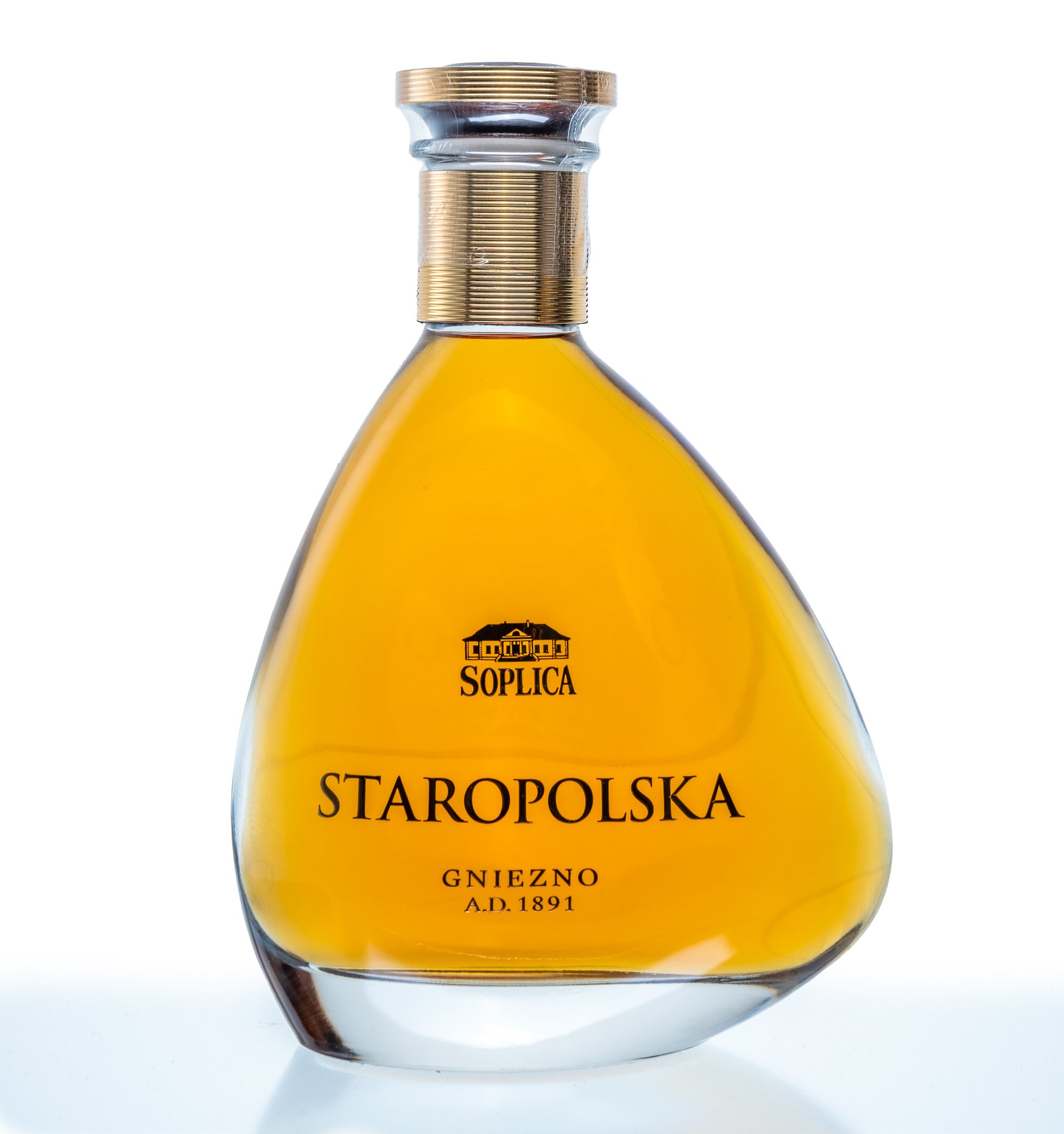Eine Flasche mit goldgelbem Öl, Beschriftung auf Polnisch, darunter Stadt Gniezno, gegründet 1891, mit goldener Schraubkappe.