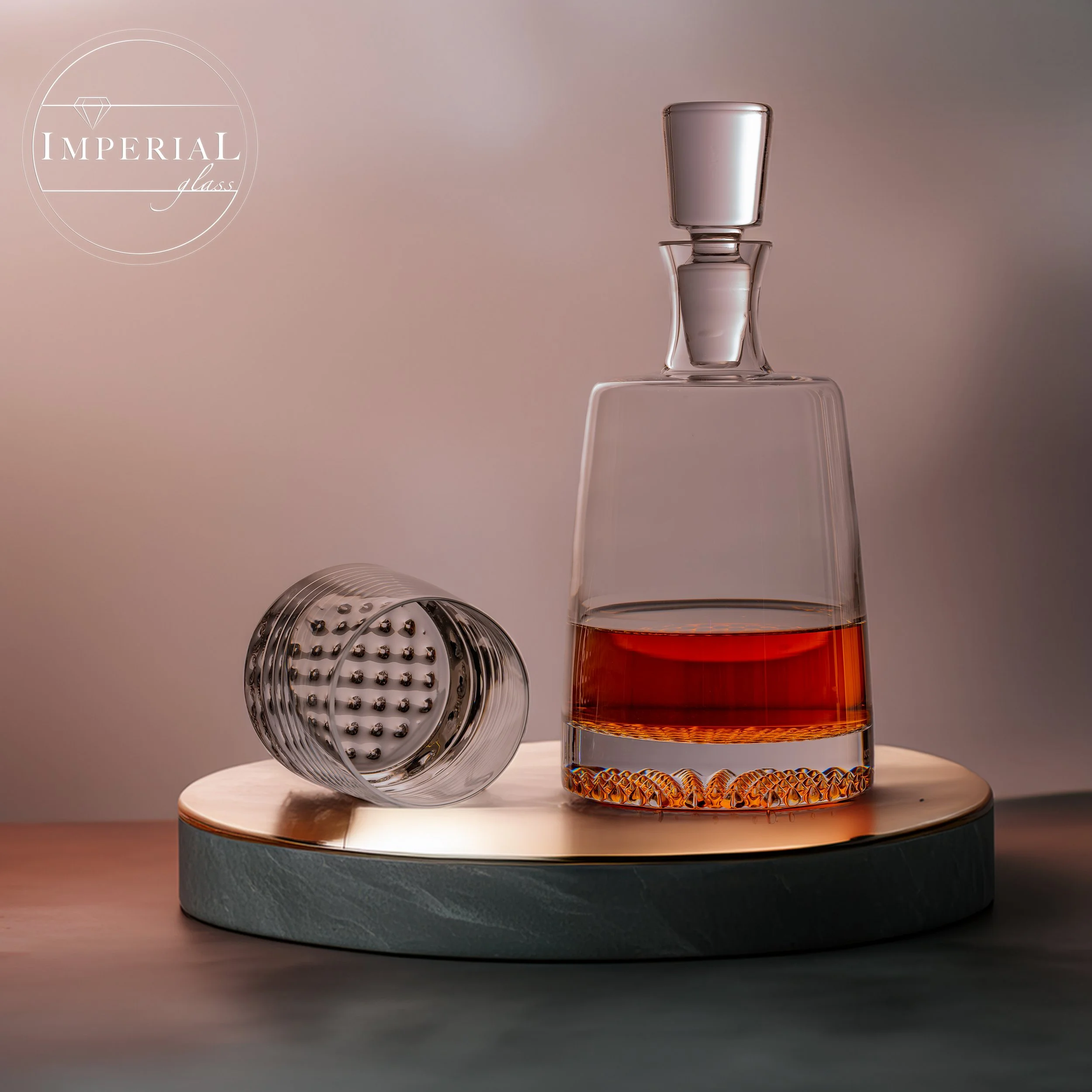 Ein Glas mit braunem Getränk steht auf einem verstärkten Glas, daneben sind zwei Trinkhalme, eines mit einem metallischen Rillenmuster, das andere mit einer glänzenden Oberfläche.