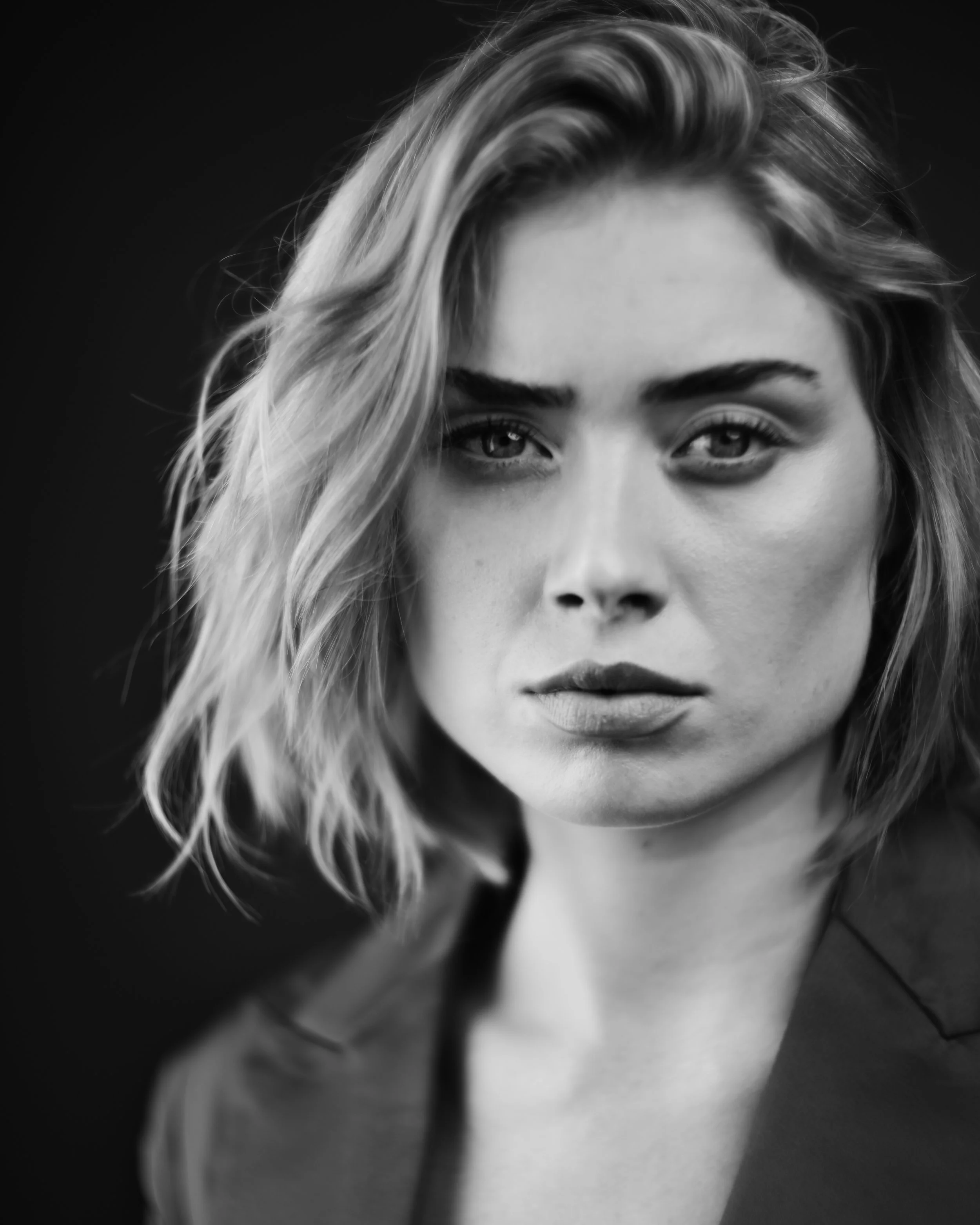 Schwarz-weiß-Fotografie eines Teils des Gesichts einer Frau mit blonden, lockigen Haaren und intensiven Blick, nervöser Ausdruck.