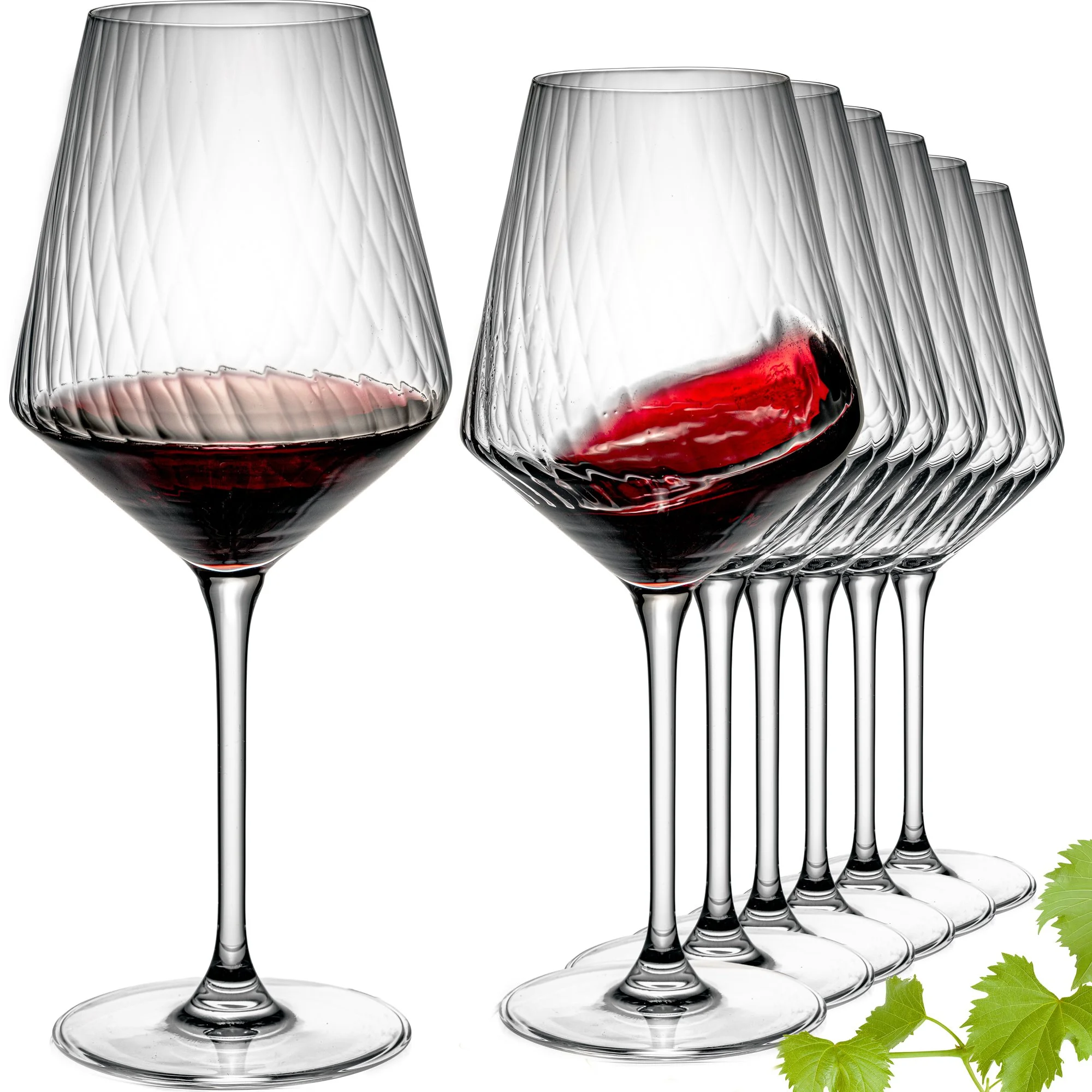 Mehrere Weingläser, zwei mit Rotwein, auf weißem Hintergrund mit grünen Weinblättern im unteren rechten Bereich.