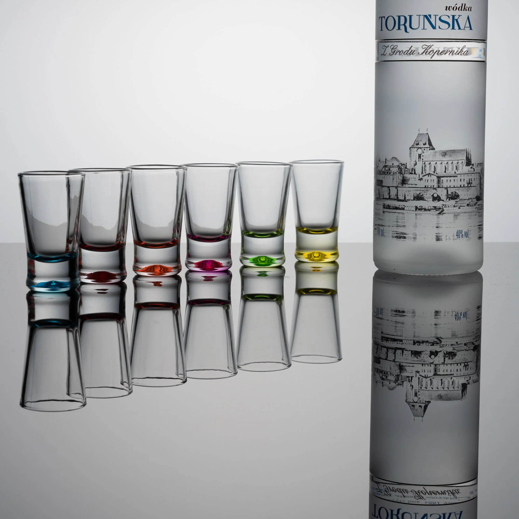 Benzinfalsche, transparente Gläser mit bunten Rändern und eine große Flasche Wodka mit einer schwarzen und weißen Sanierung des Stadtbildes.
