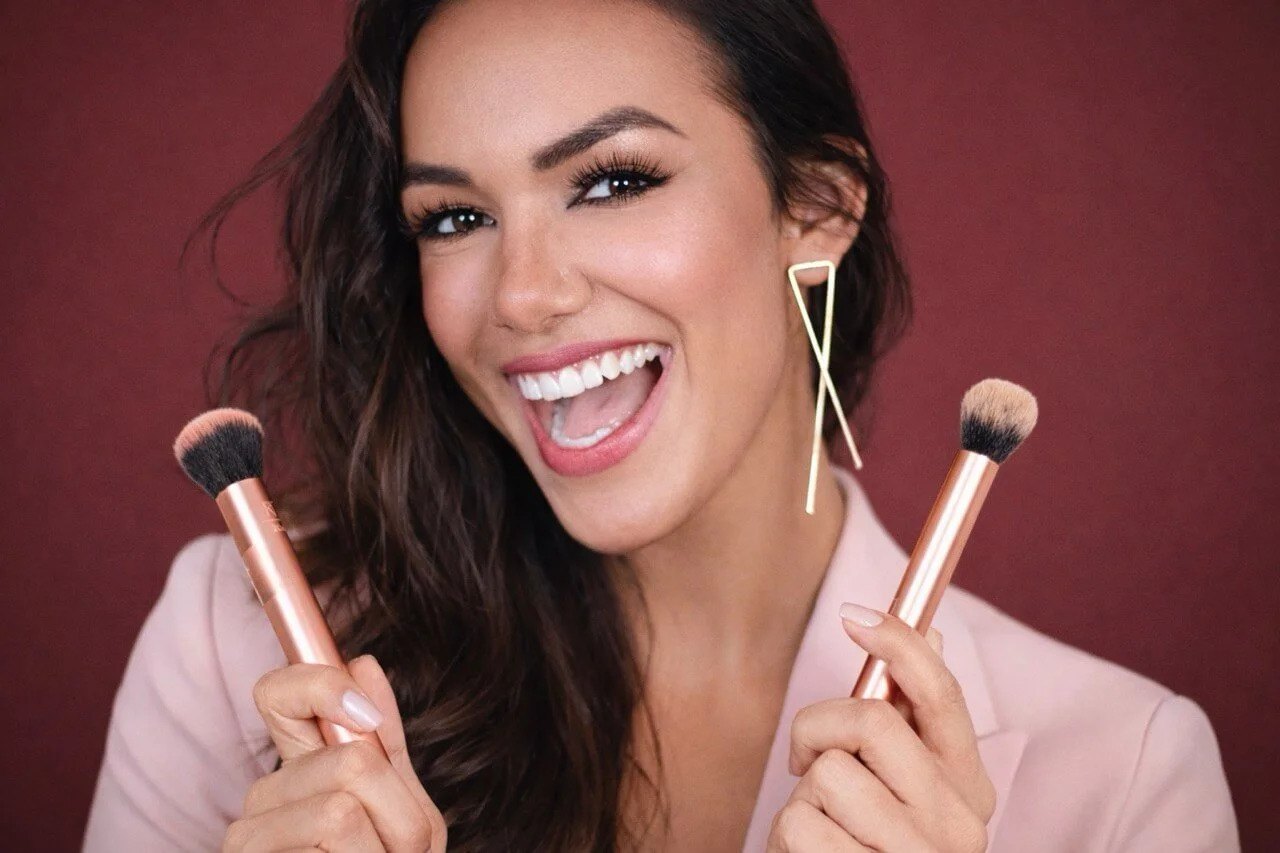 Lara Claudy, bridal makeup artist in Philadelphia, holding makeup brushes