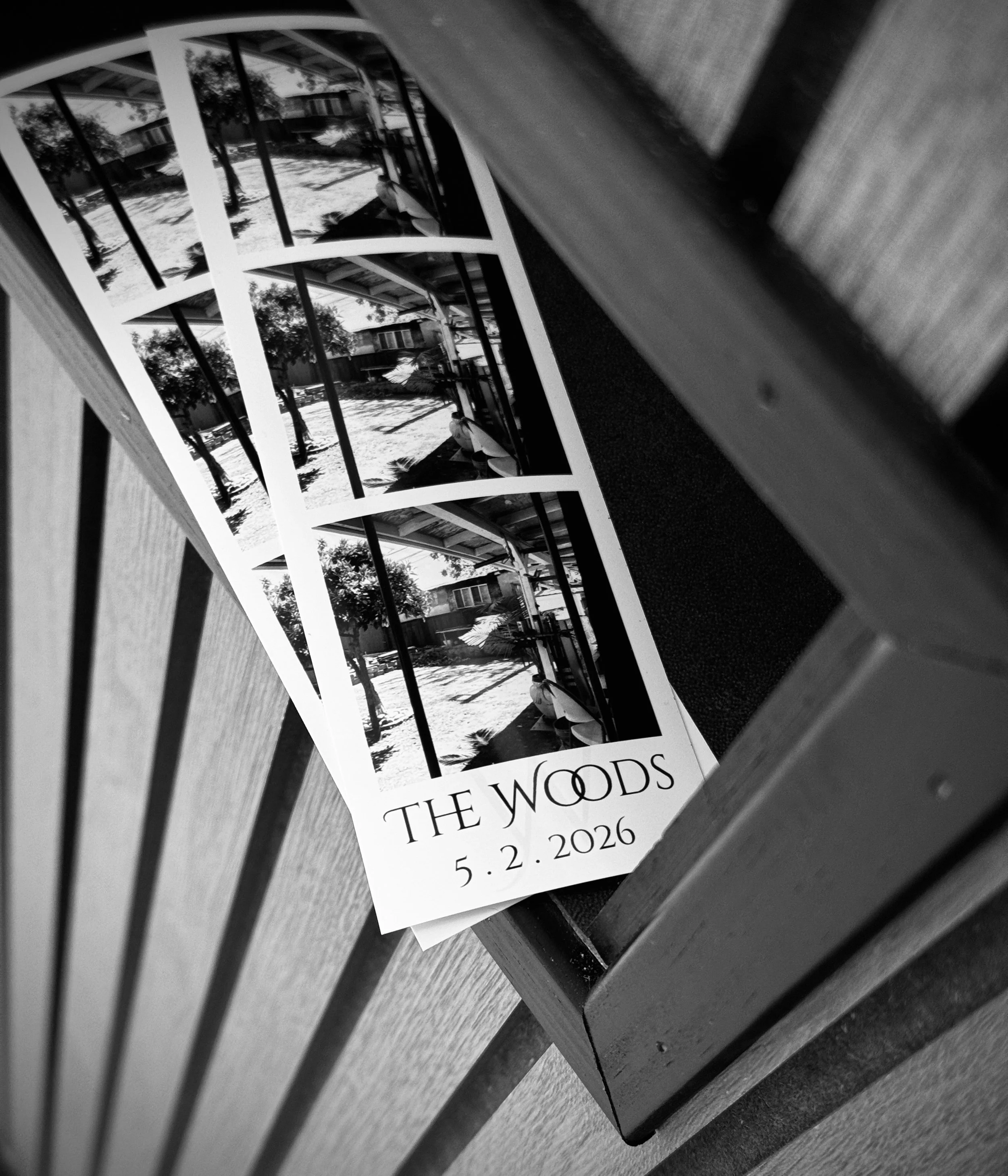 A black and white photo of a 2x6 photo strips designed for a wedding, placed on the landing tray of the Velvet & Oak Photo Booth. This photo invoked warmth and makes engaged couples want to book this Photo Booth.