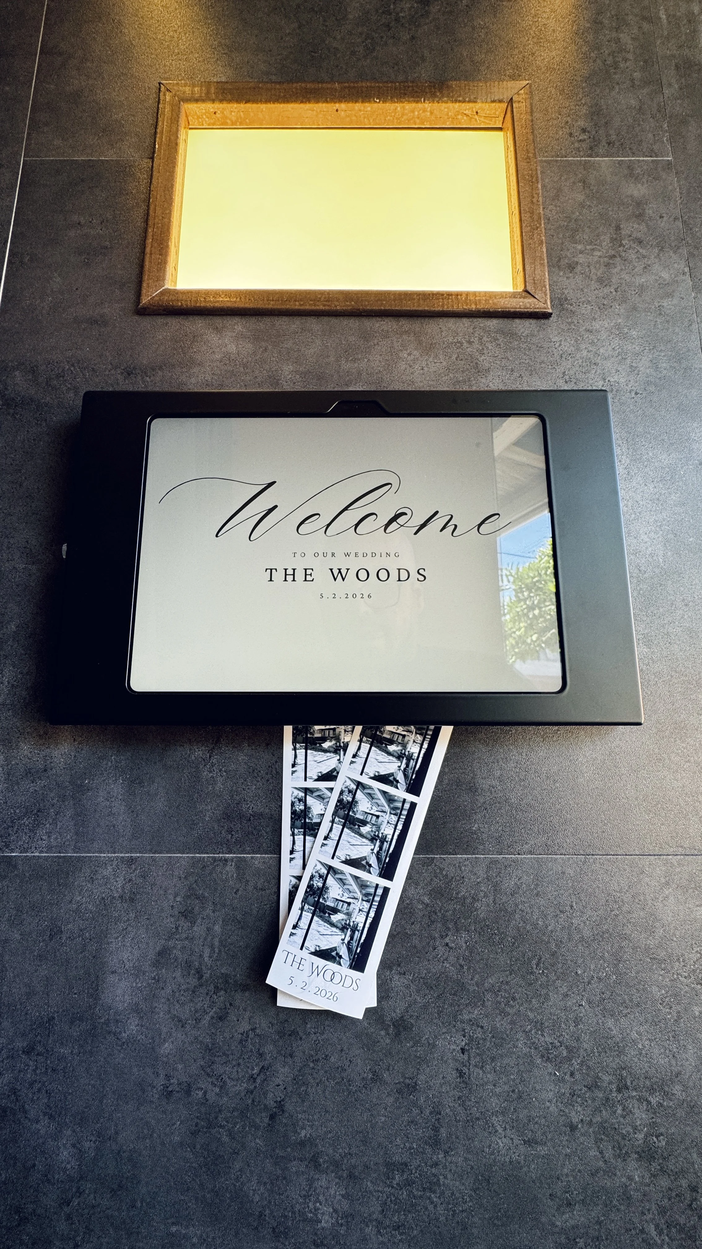 A "welcome to our wedding" sign on a luxury Photo Booth with photo strips