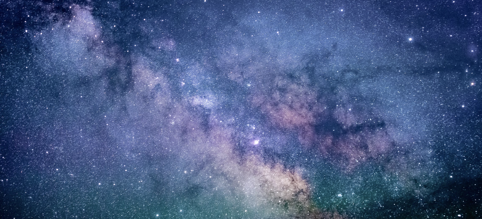 A clear night sky filled with countless stars and the Milky Way galaxy visible across the sky.