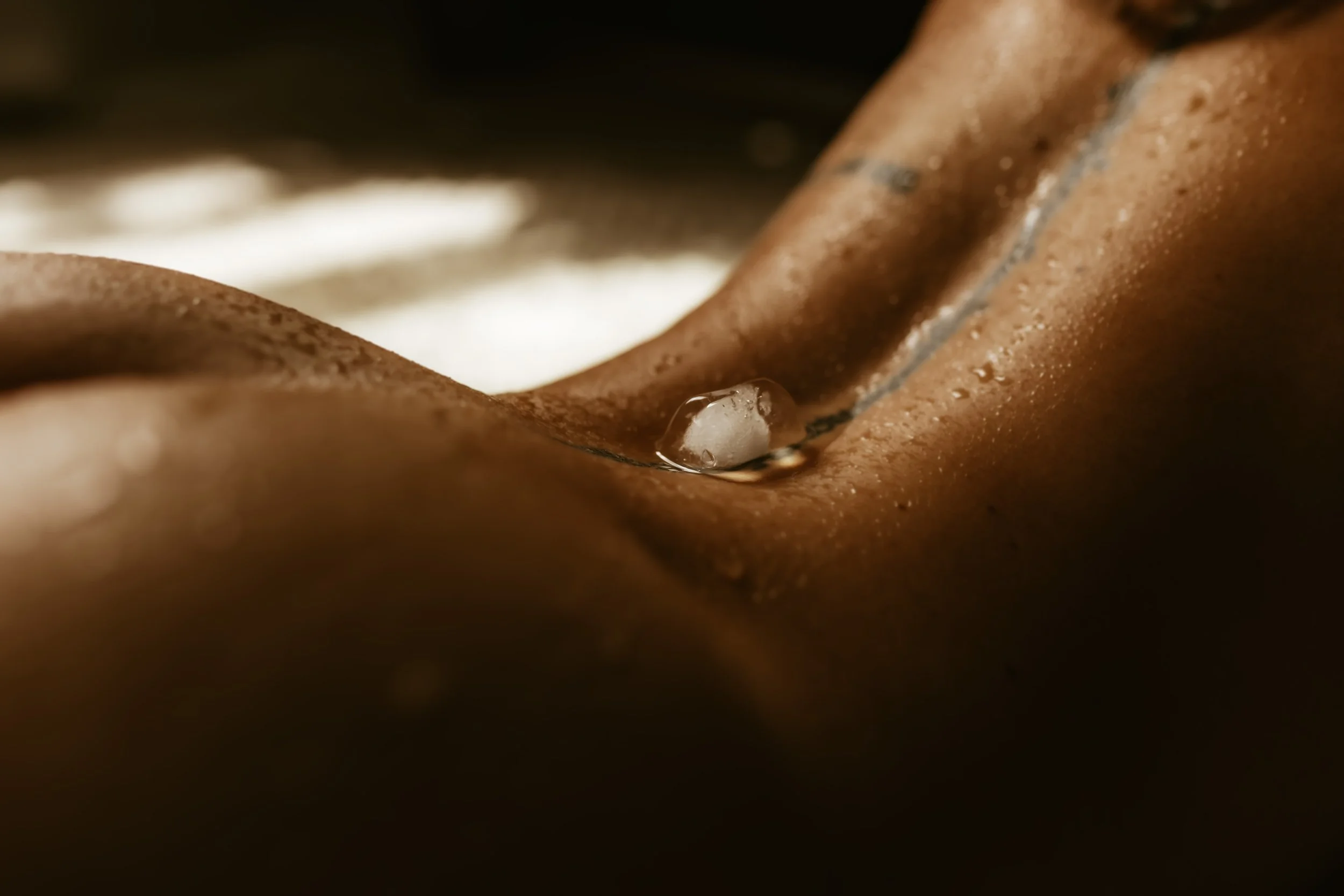 Close-up of a person using a lava lamp, with water and a small bubble on a brown surface.