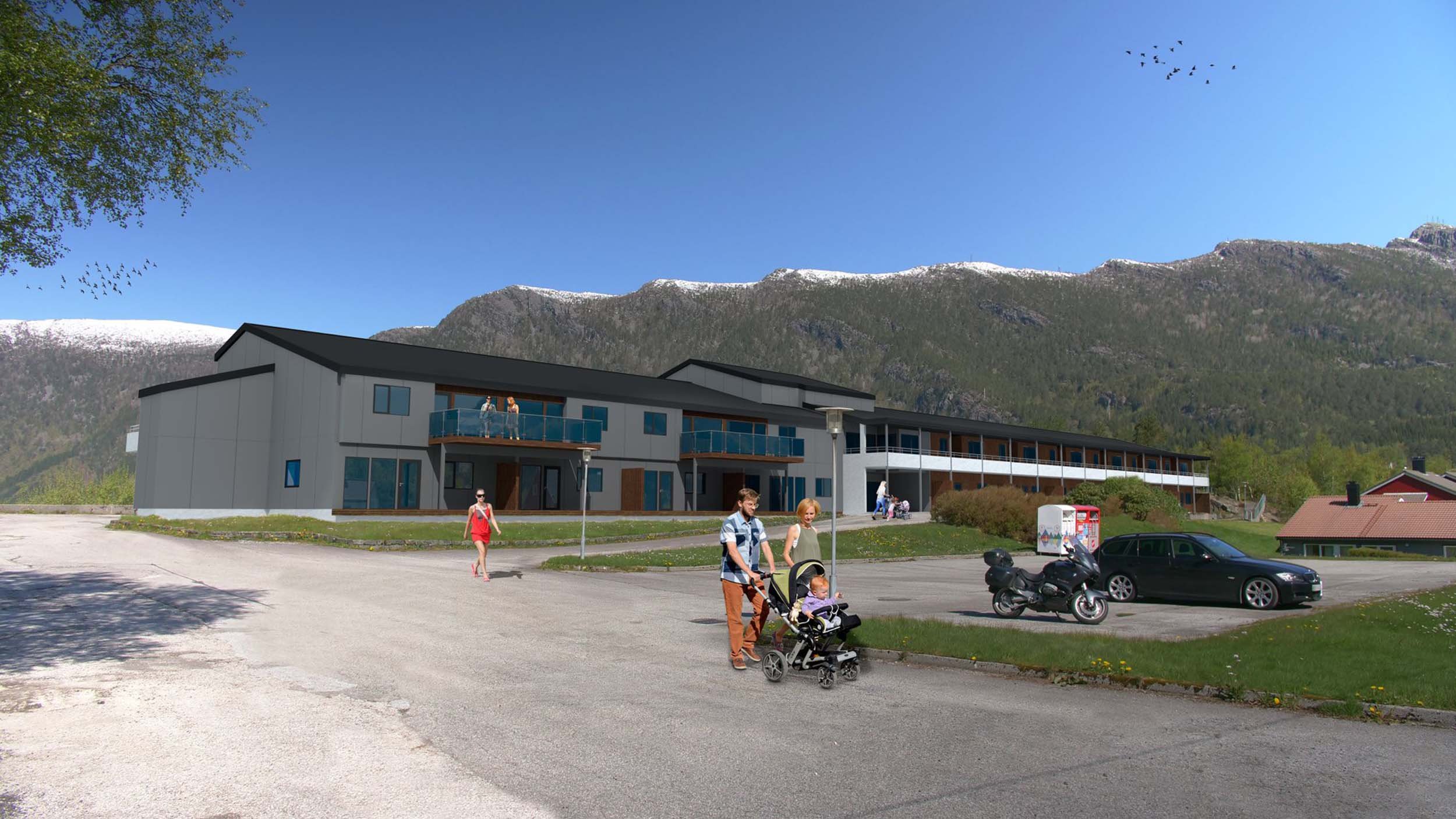 En moderne bygning med utsikt mot fjell med snø, personer som går og drar barnevogn, biler og motorsykkel i parkeringsareal.
