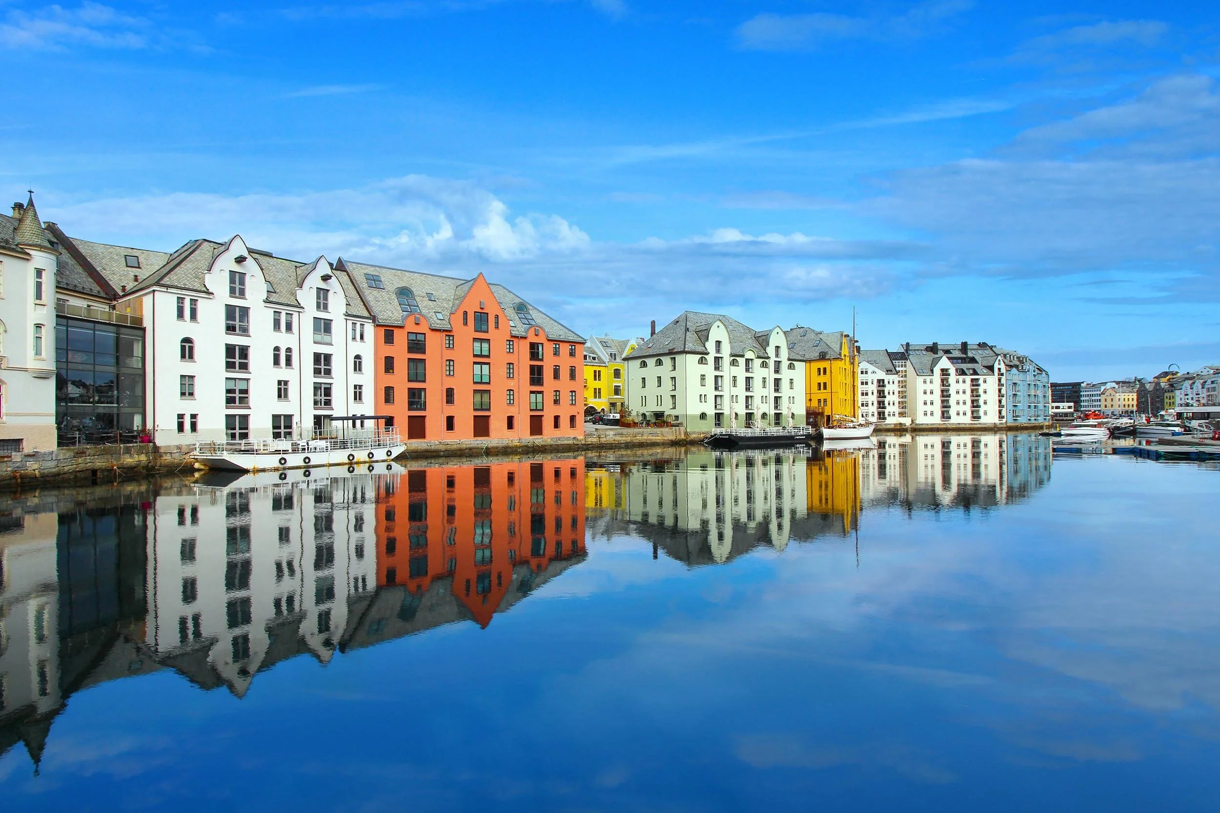 Fargerike bygninger langs en vannkyst under en blå himmel