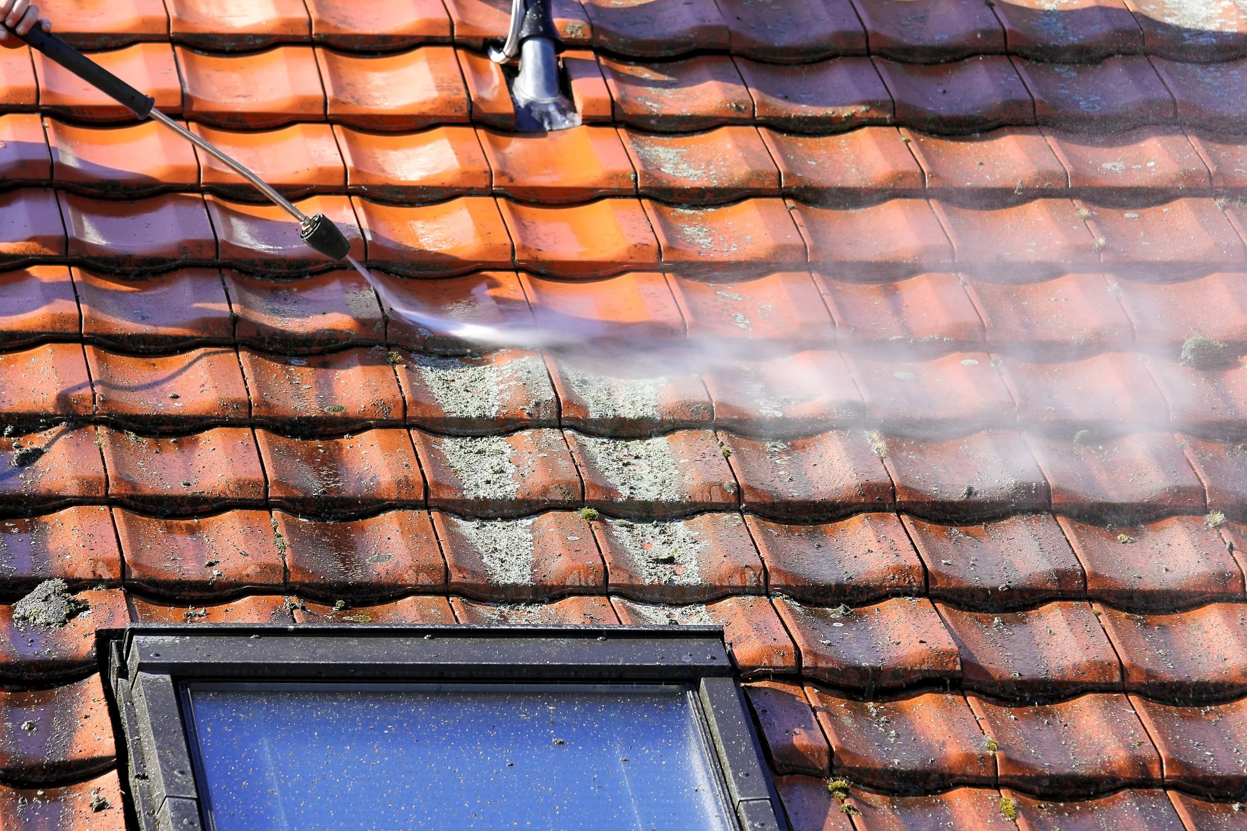 Power washing a roof with orange tiles