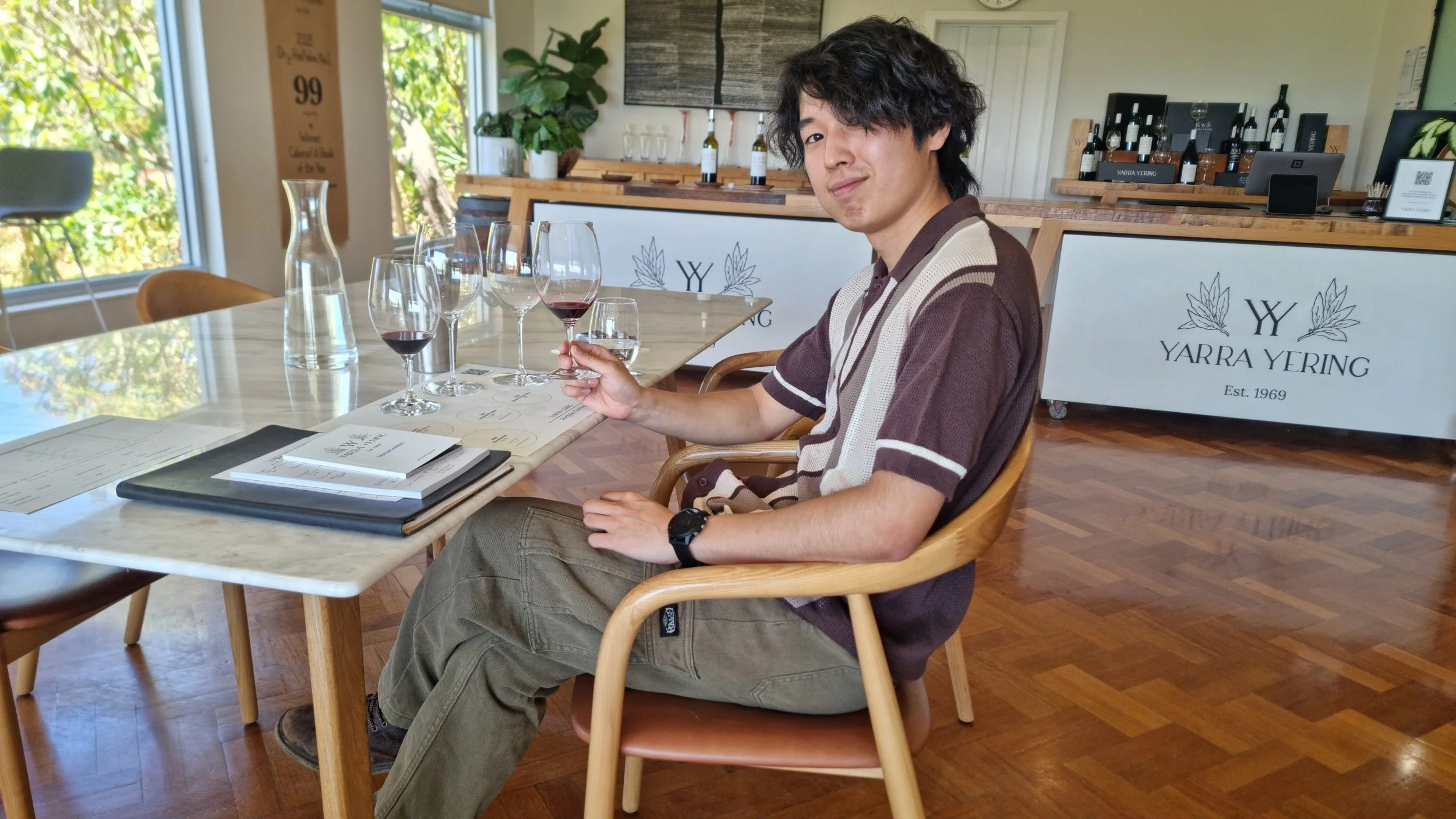 ワイナリーでワインの試飲を楽しむ男性の写真